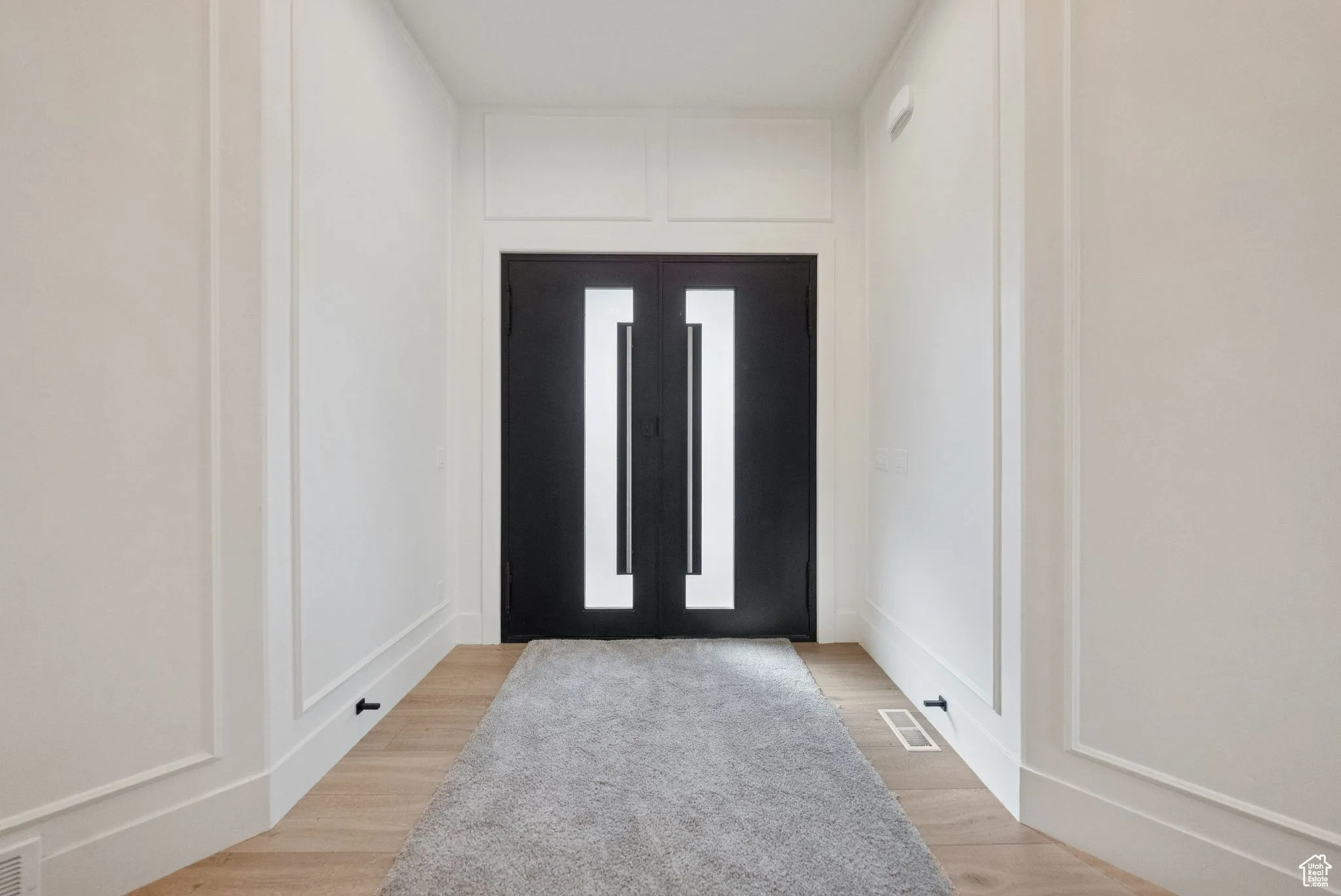 Foyer featuring a decorative wall and light wood-style flooring