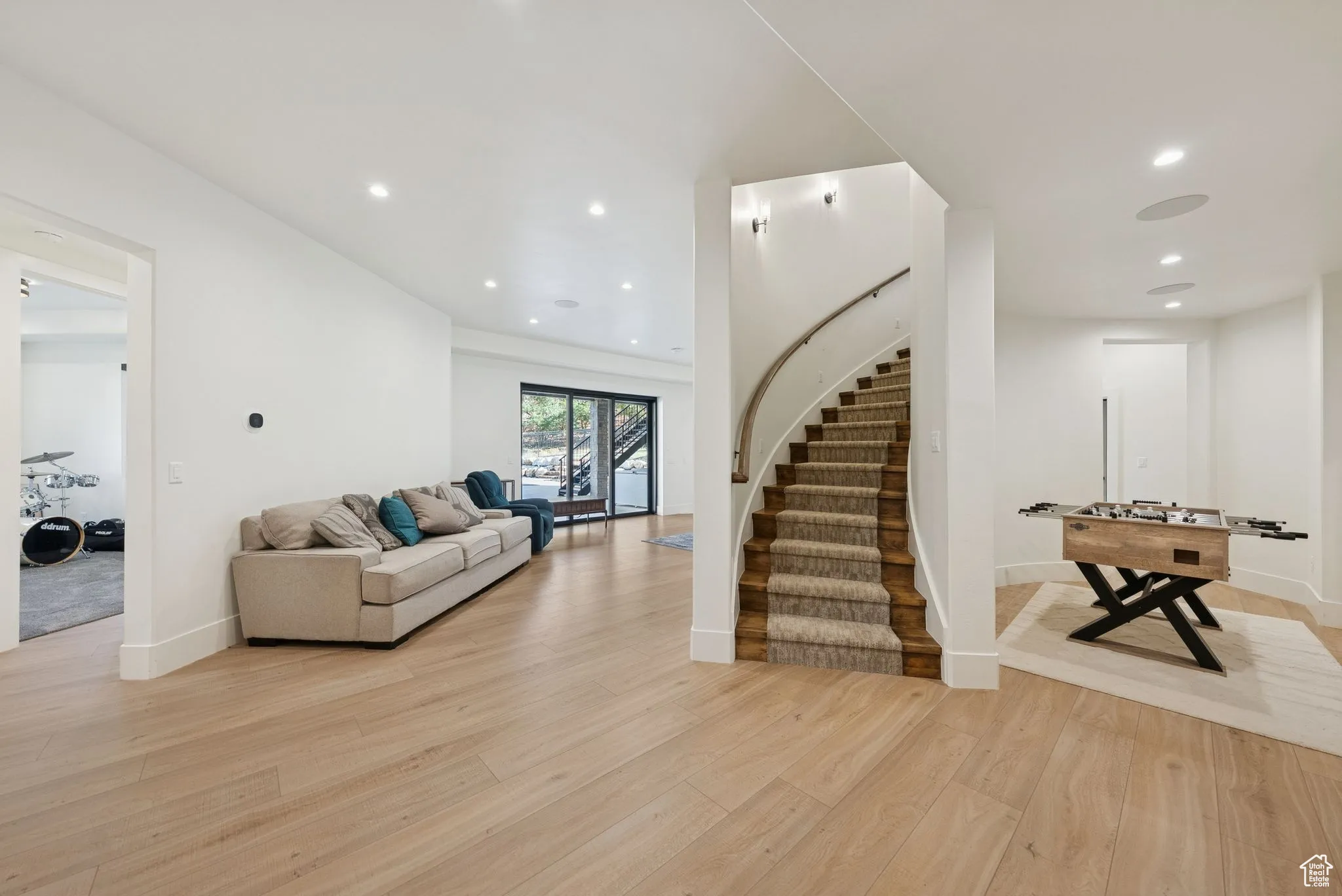 Living room featuring recessed lighting, light wood-style floors, and stairway