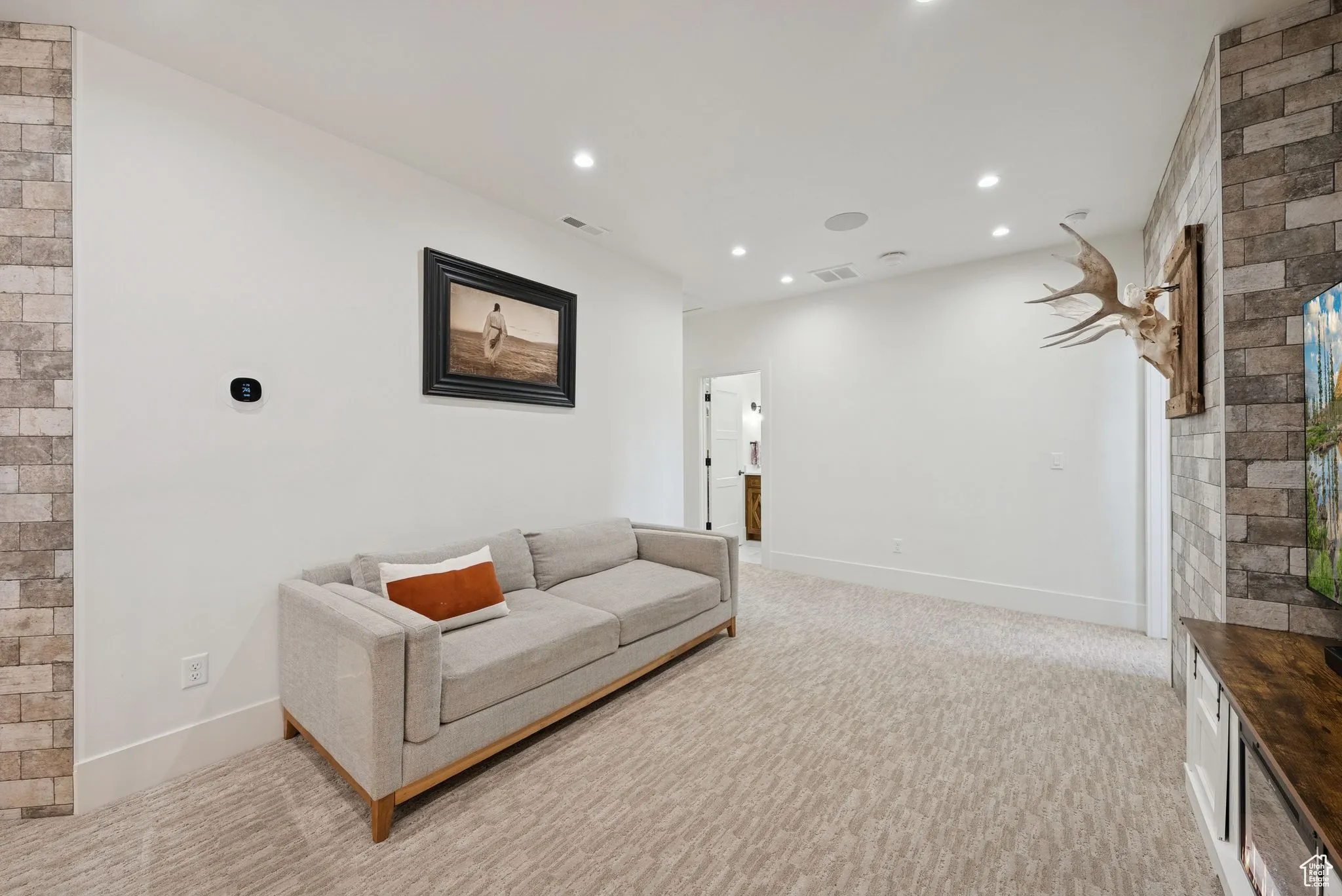 Sitting room with light colored carpet and recessed lighting