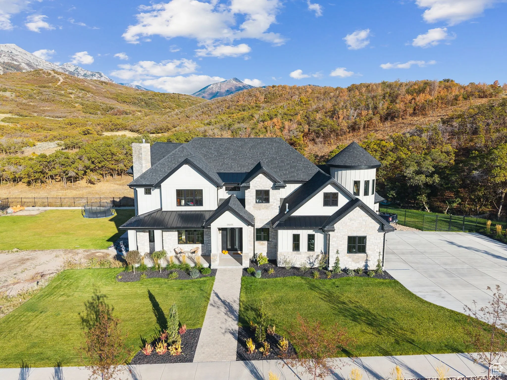 Modern inspired farmhouse featuring a standing seam roof, a metal roof, board and batten siding, and a chimney