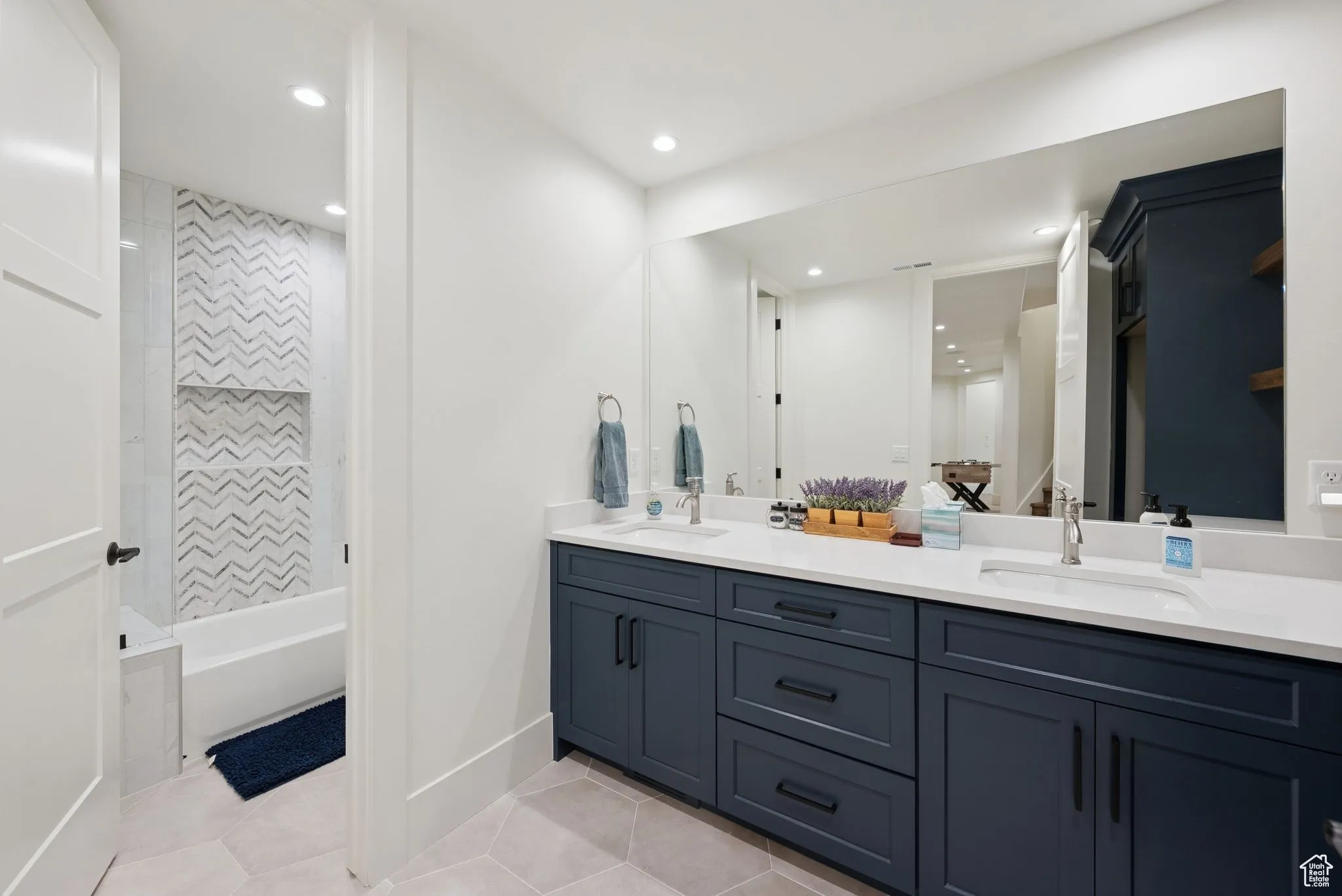 Bathroom featuring double vanity, light tile patterned floors, shower / bath combination, and recessed lighting