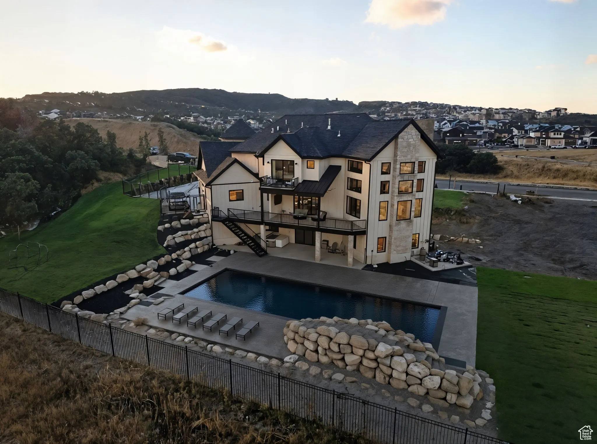 Back of house with stairway, a patio area, stucco siding, and a balcony