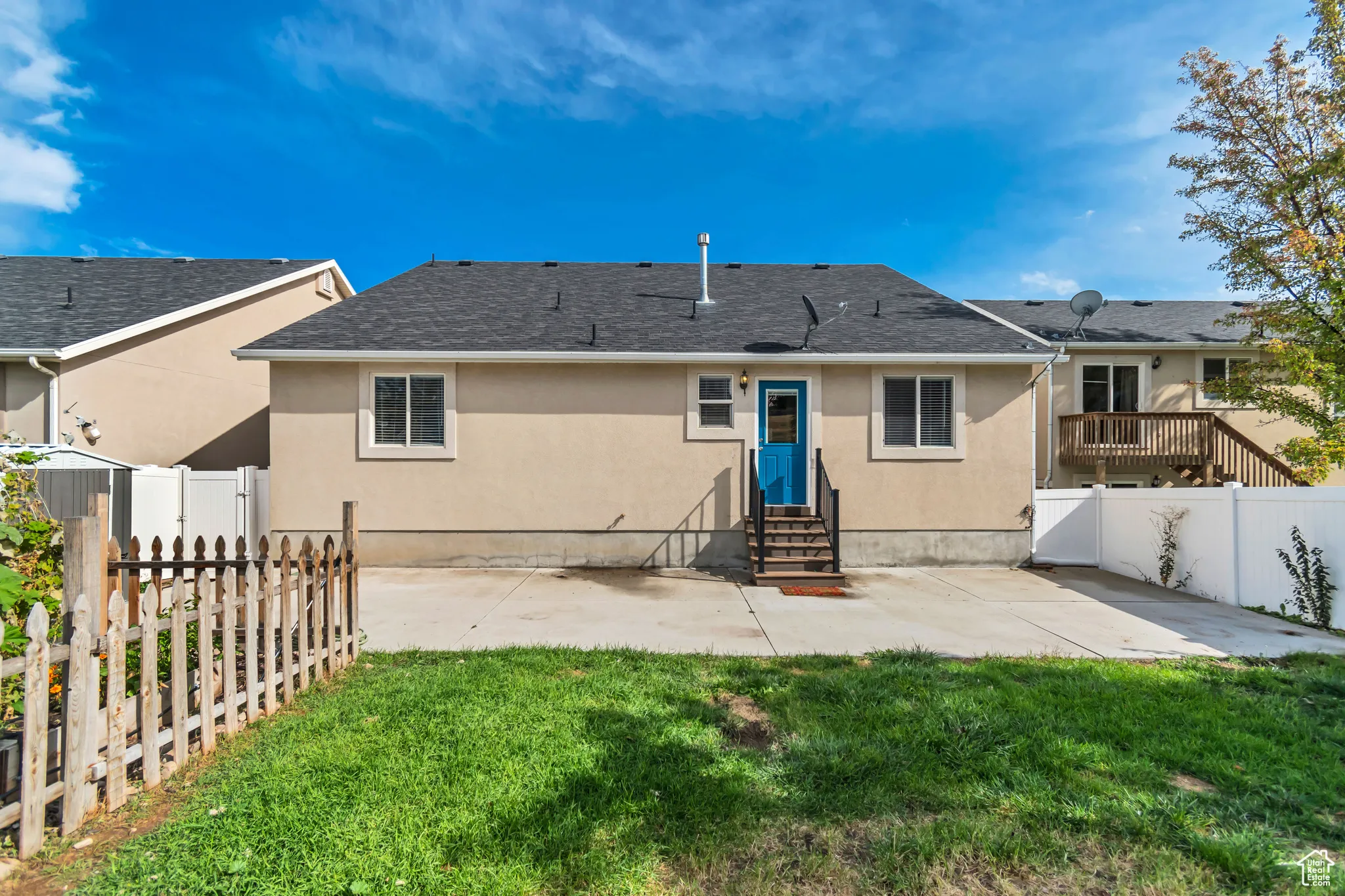 Rear view of house featuring a patio area, stucco siding, a fenced backyard, entry steps, and a shingled roof