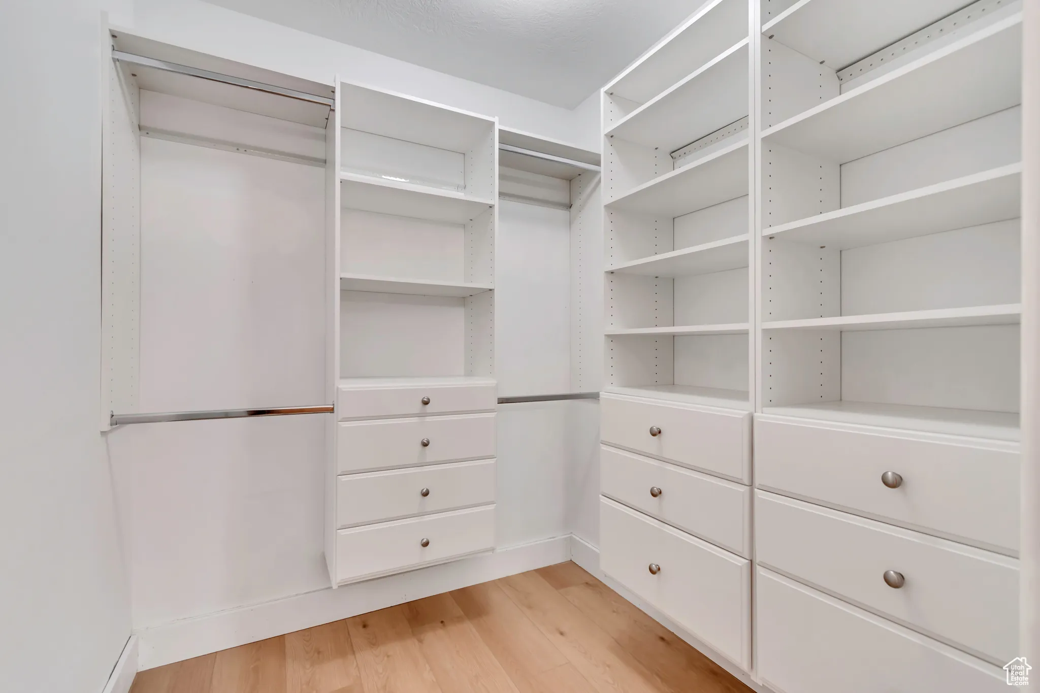 Walk-in closet with light wood-style floors