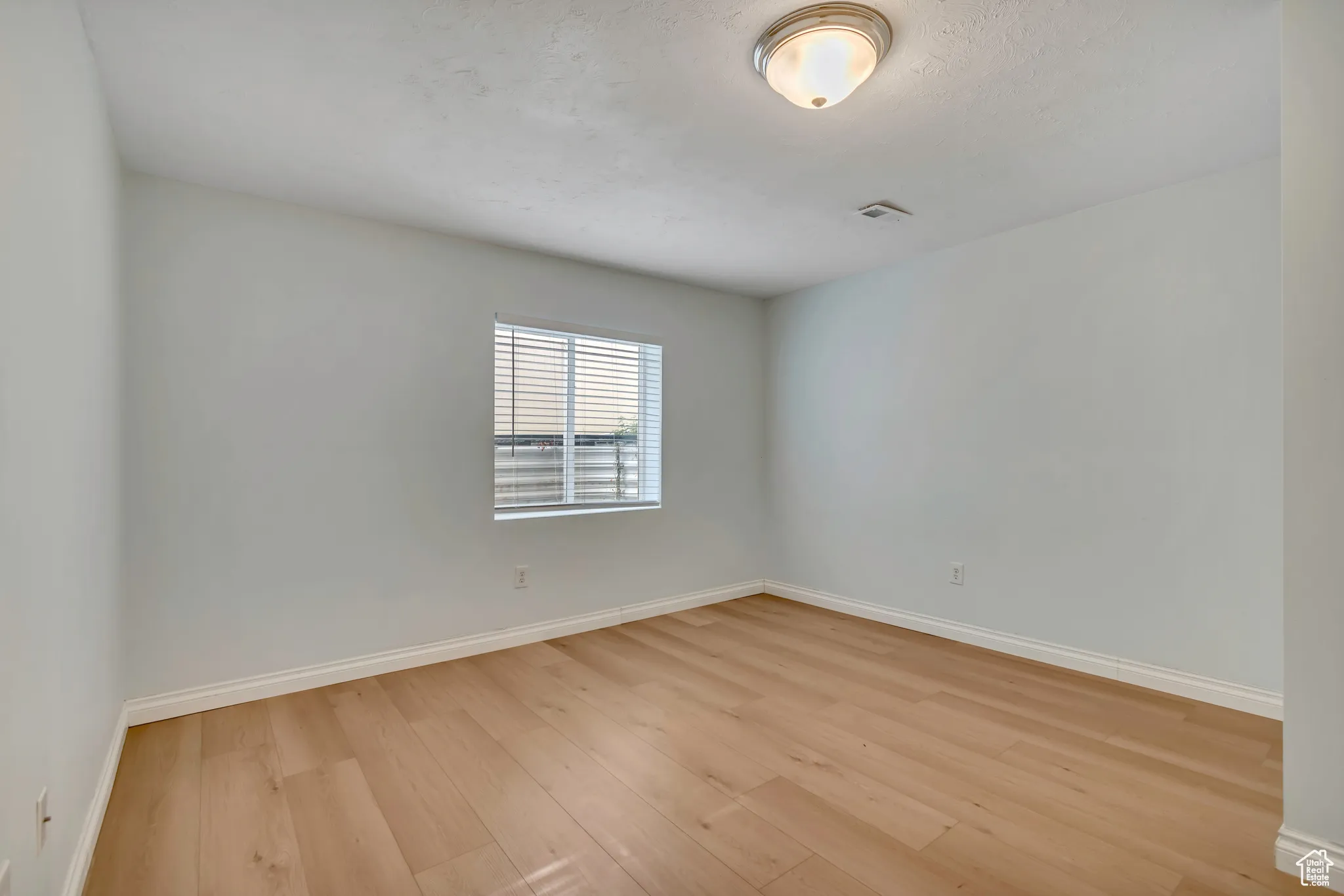 Basement bedroom featuring baseboards and light wood-style floors