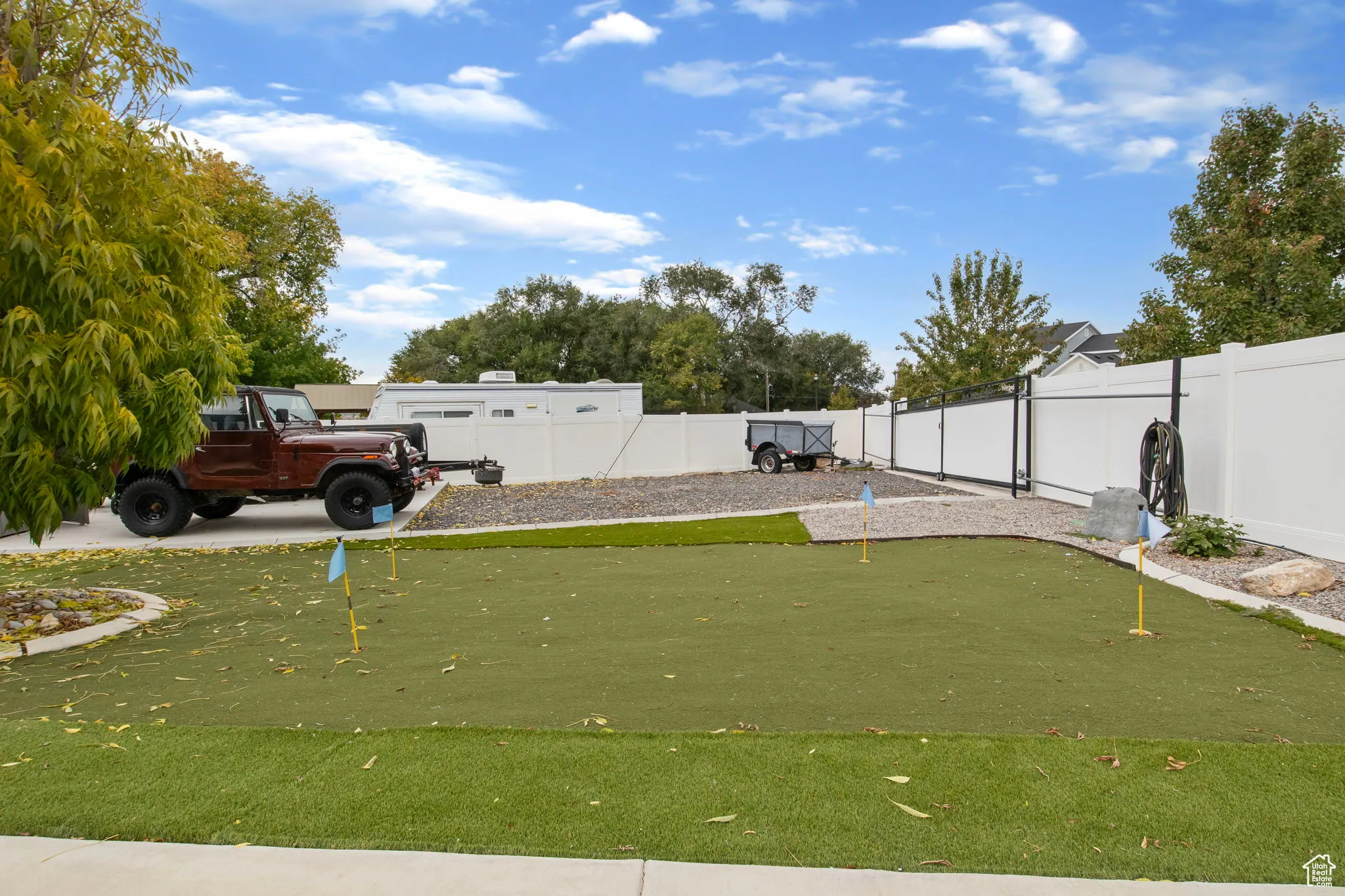 Fenced backyard with a putting area