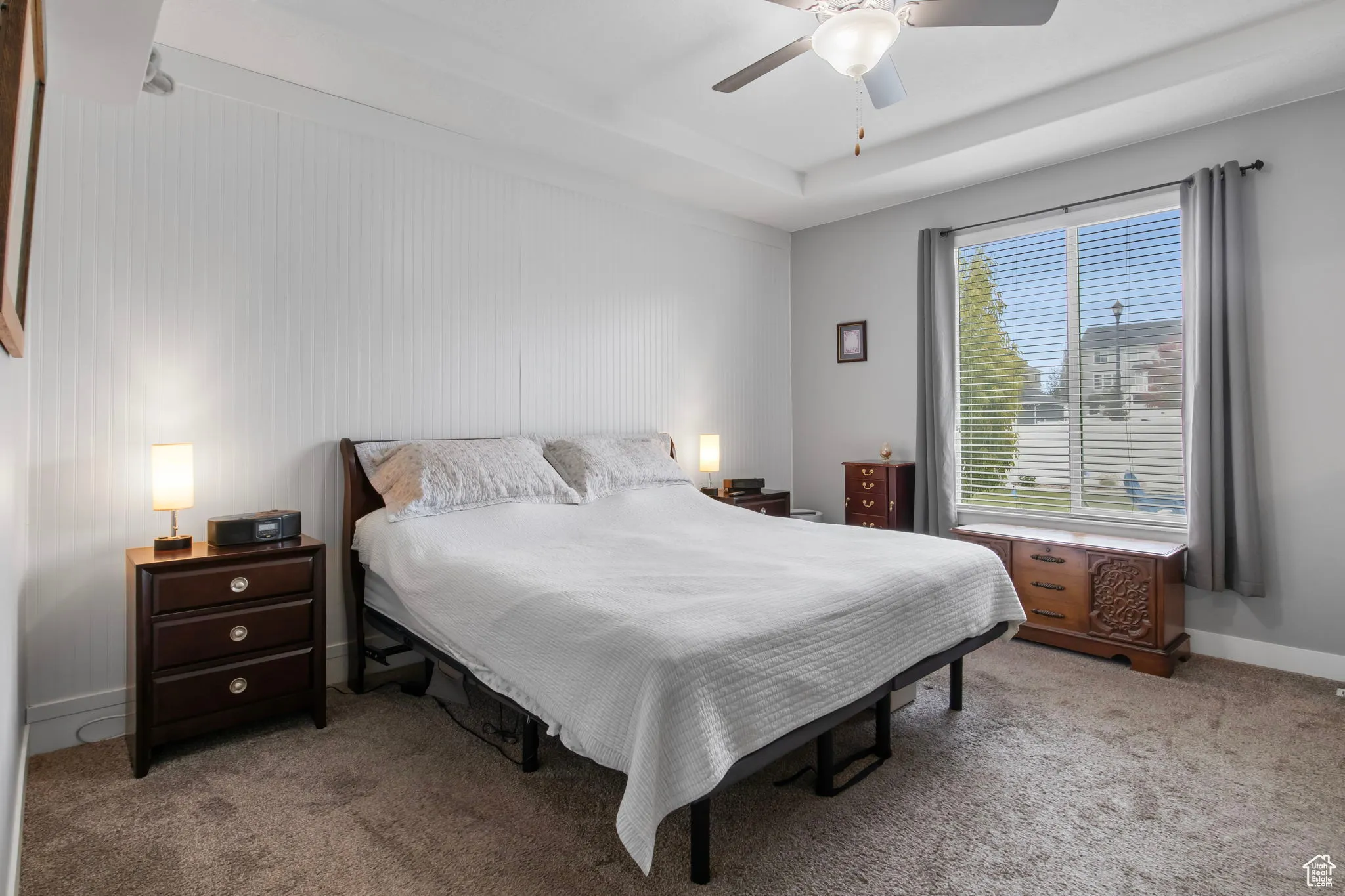 Carpeted bedroom with baseboards and a ceiling fan
