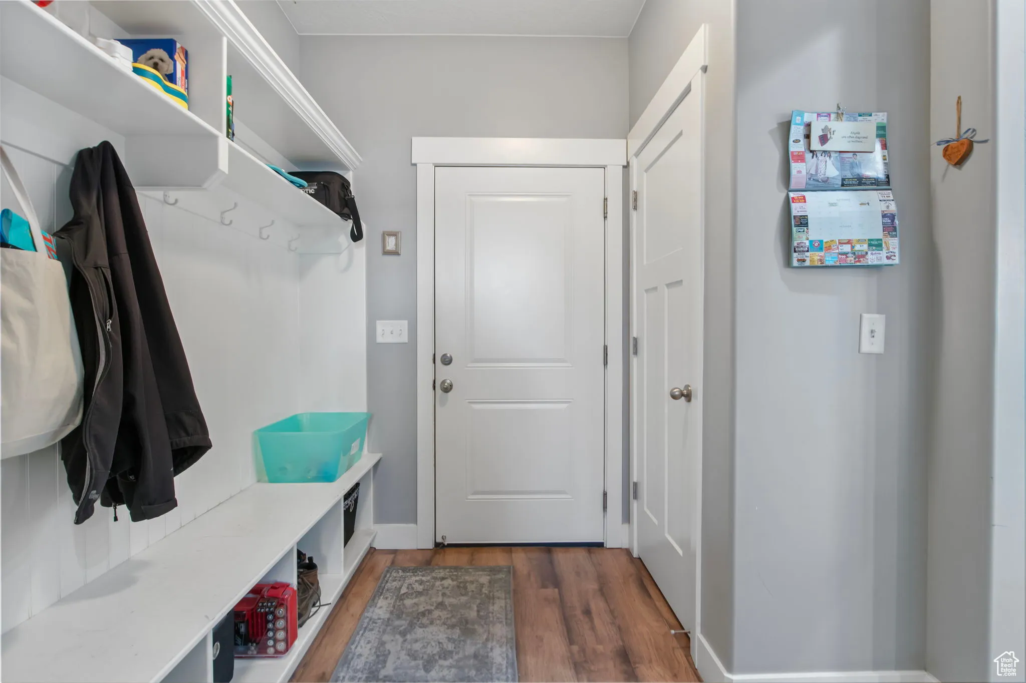 Mudroom featuring dark wood-style floors and baseboards