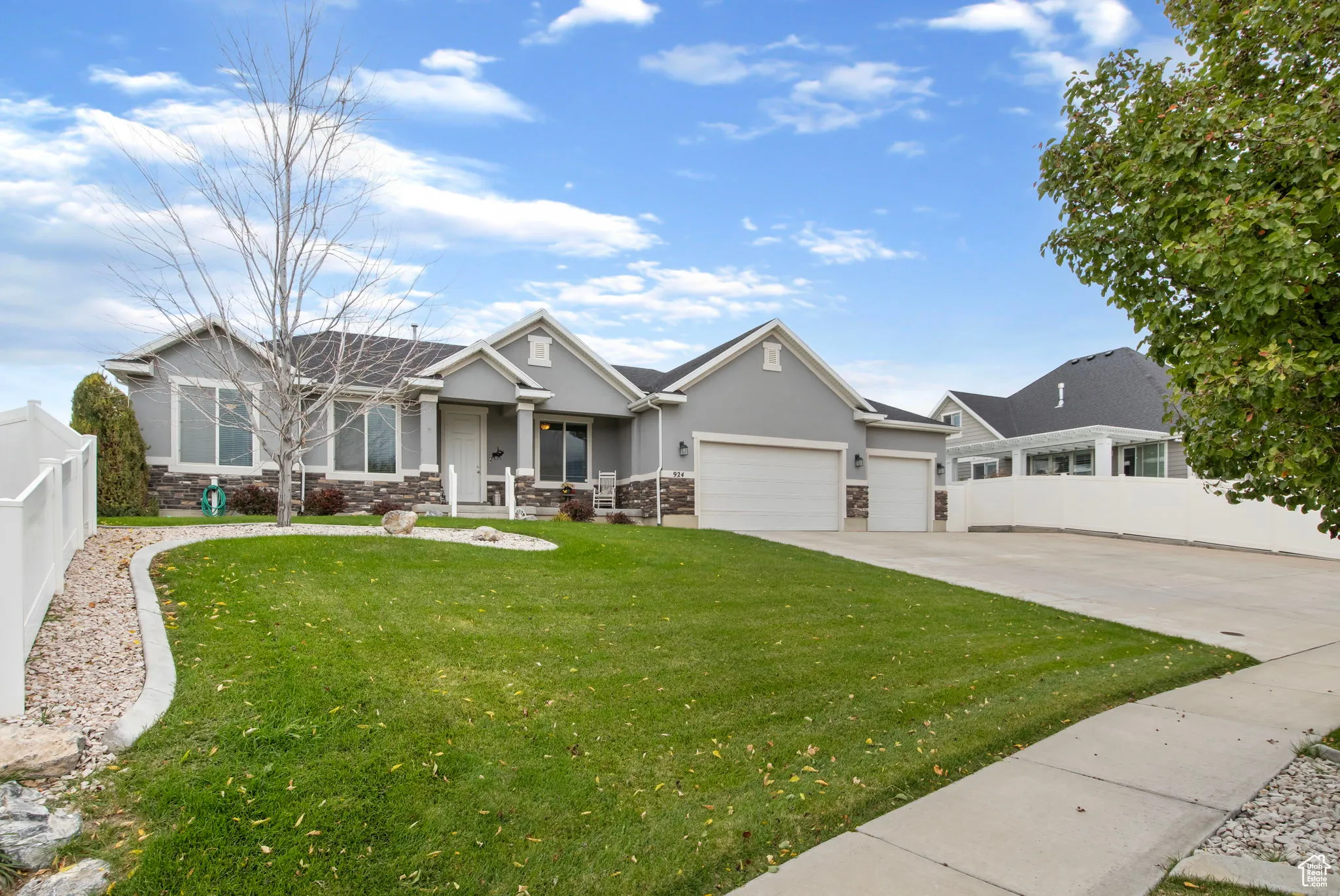 Craftsman house with driveway, stone siding, a garage, and stucco siding