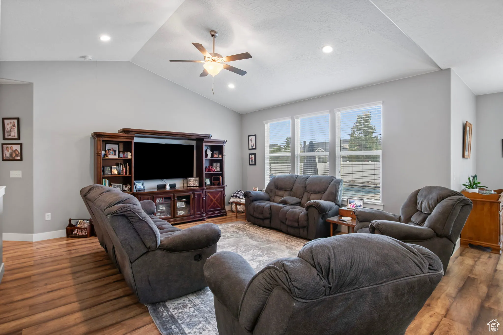 Living area with vaulted ceiling, wood finished floors, ceiling fan, and recessed lighting