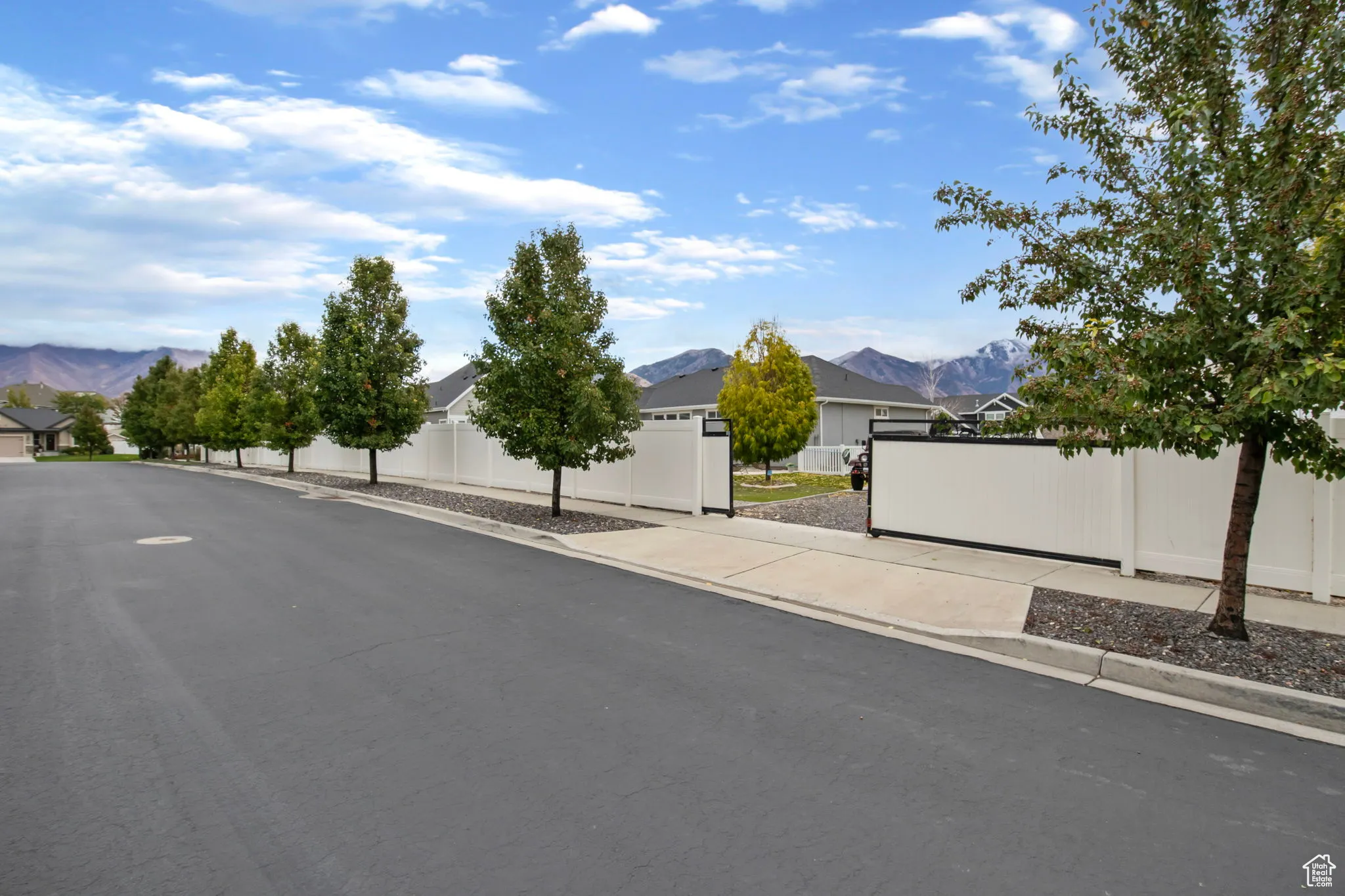 View of asphalt street with a mountain view, curbs, and sidewalks