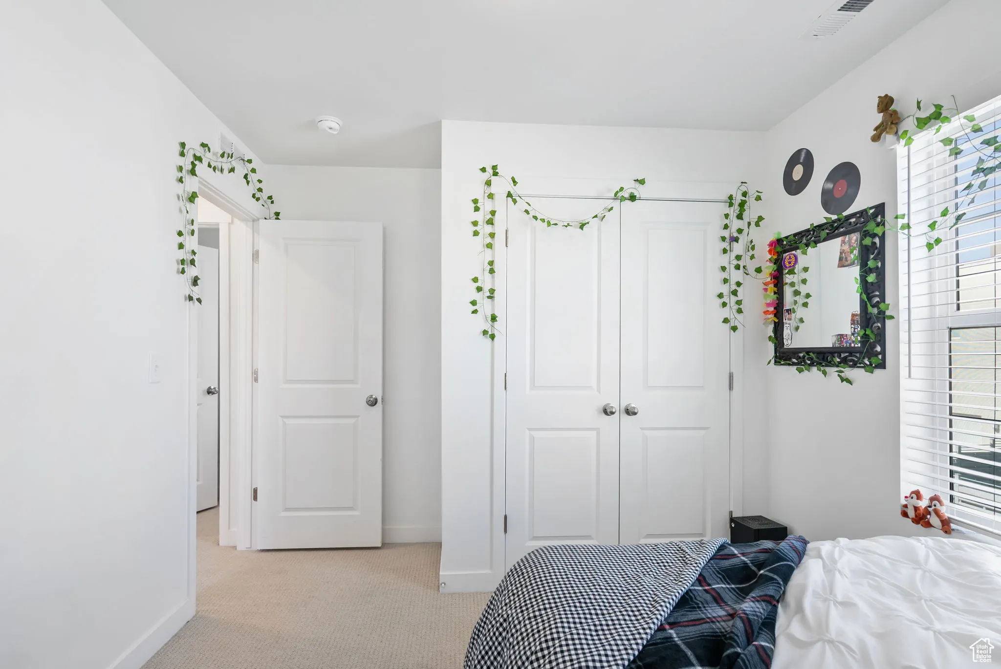 Bedroom with light colored carpet and a closet