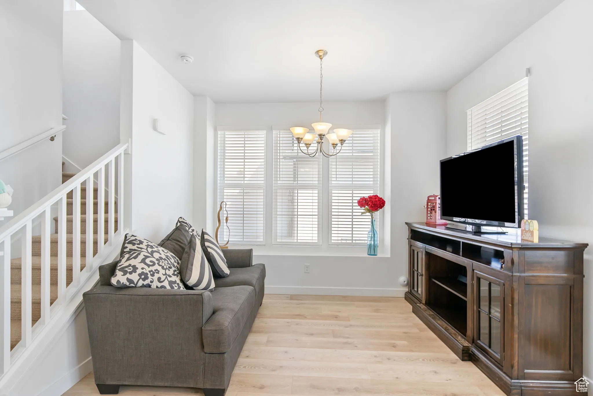 Sitting room featuring light wood finished floors, a chandelier, and stairs