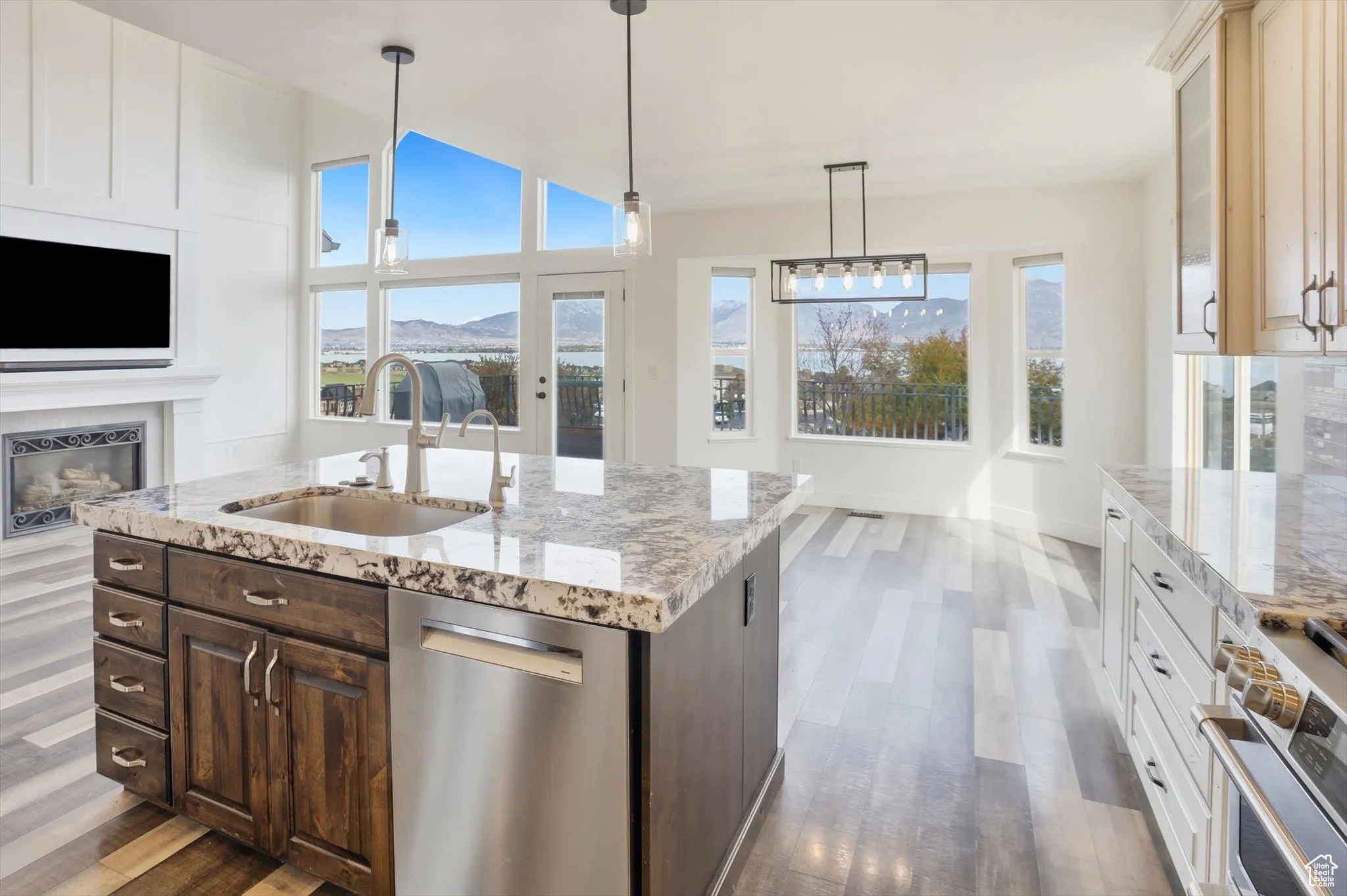 Kitchen featuring pendant lighting, stainless steel appliances, a fireplace, and dark brown cabinetry