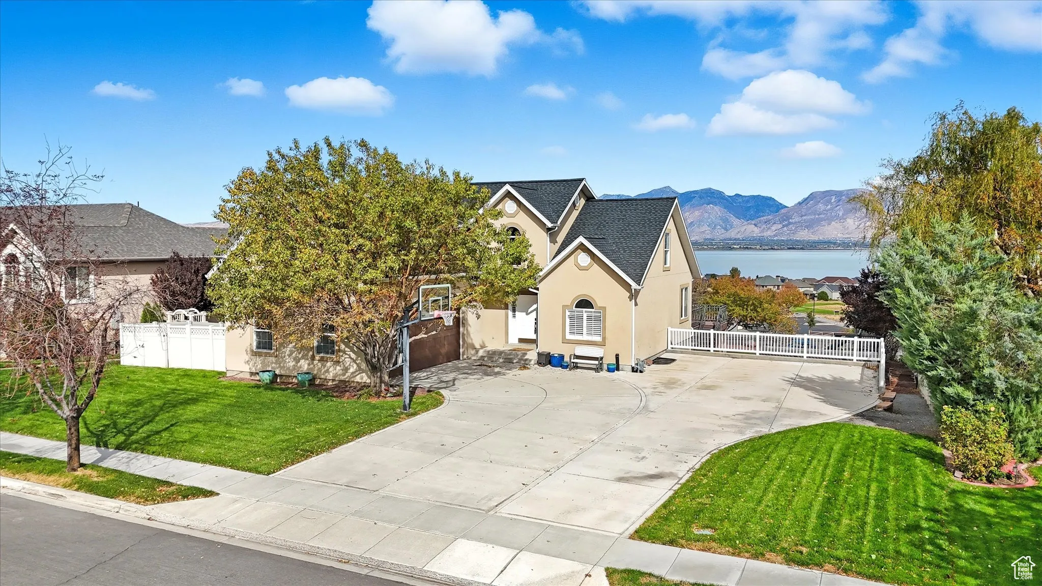 View of front of house featuring stucco siding, driveway, and a water and mountain view