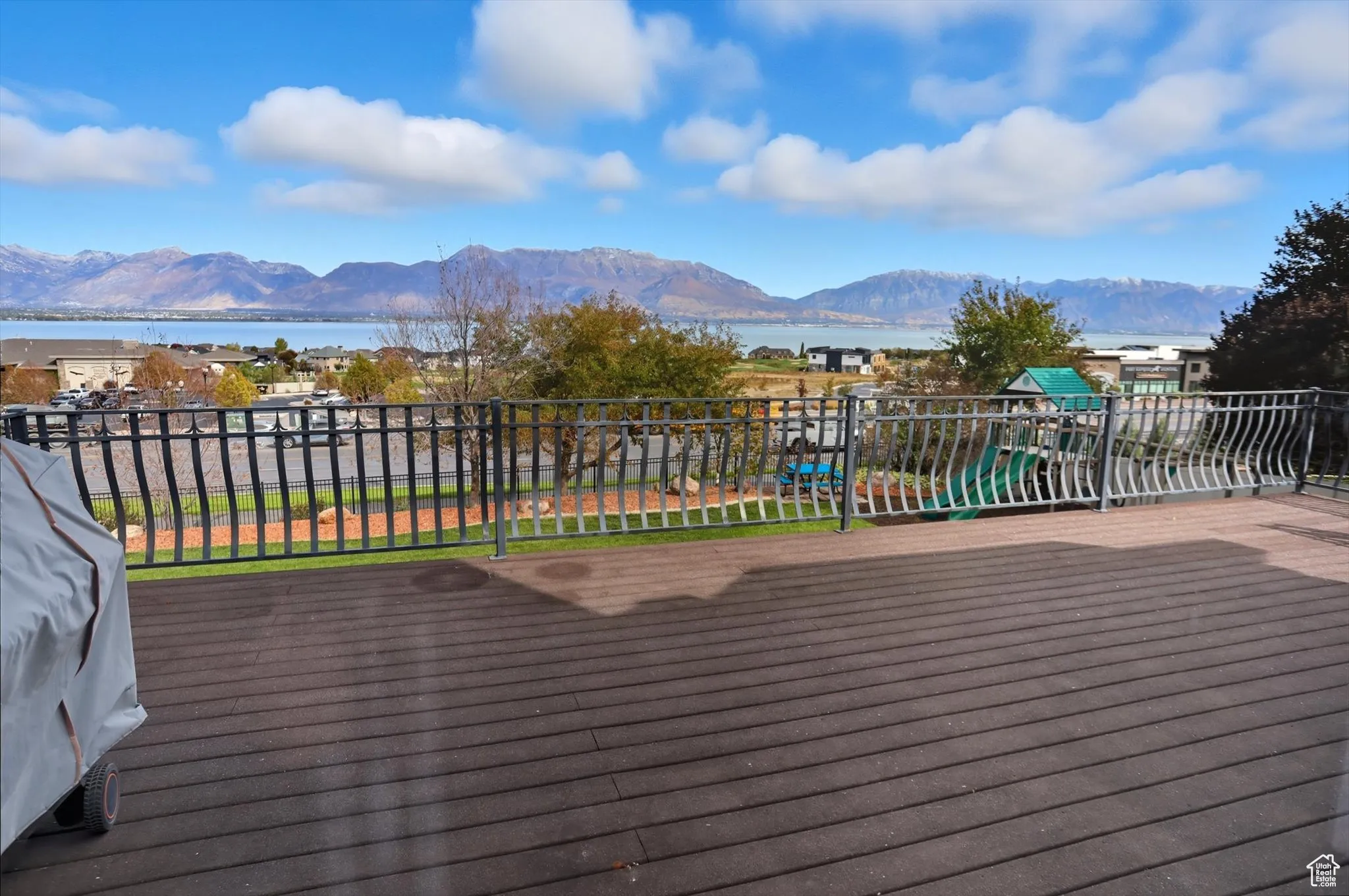 Deck featuring a playground, a water and mountain view, and a grill