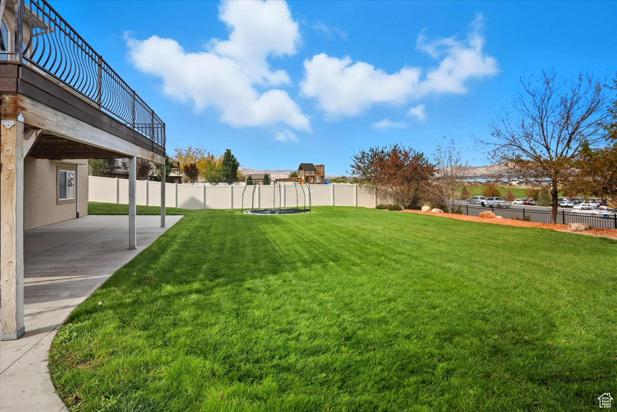 Fenced backyard with a trampoline and a patio area