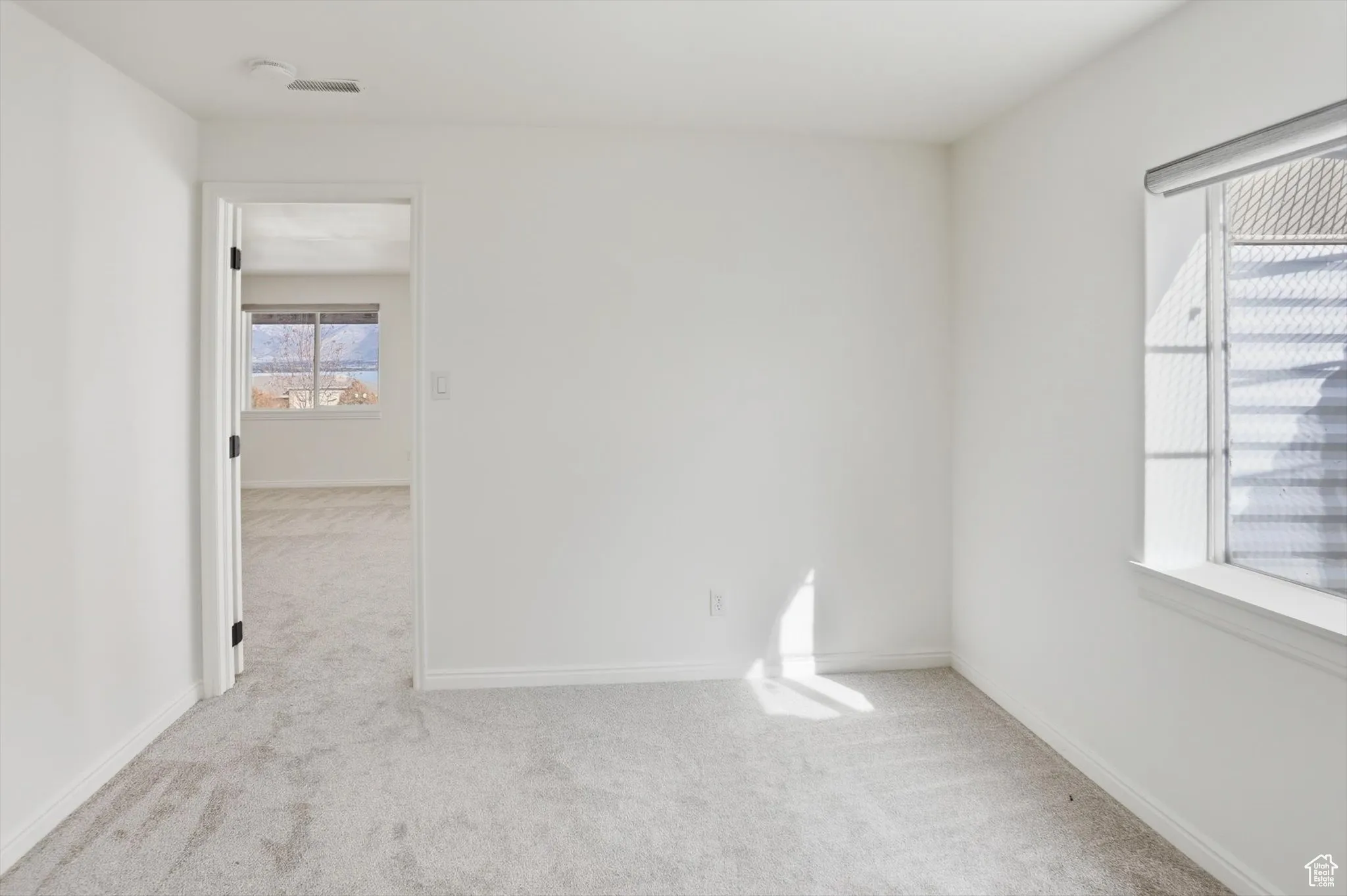 Spare room with light carpet and baseboards