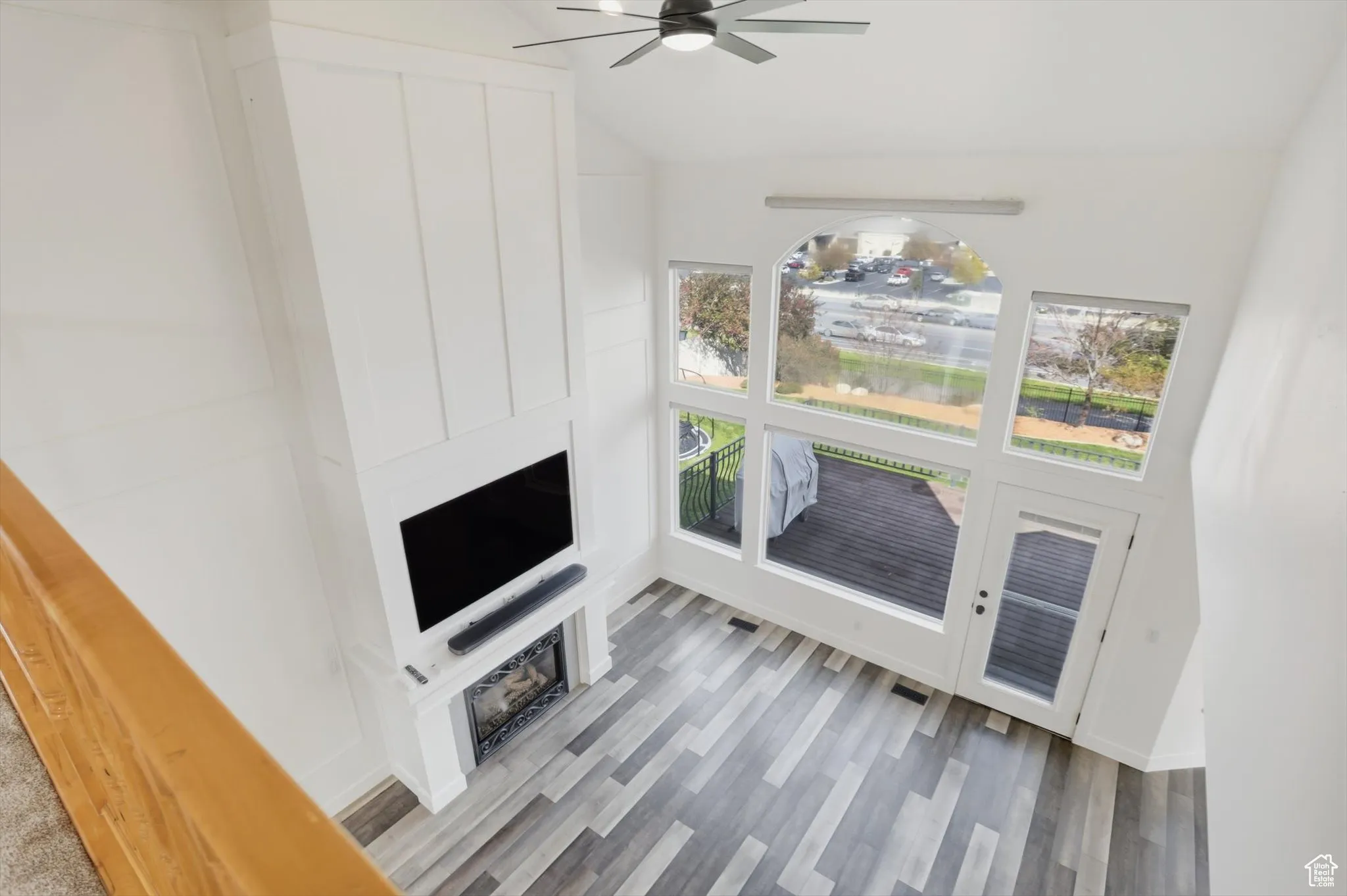 Unfurnished living room with light wood-style floors, a ceiling fan, and lofted ceiling