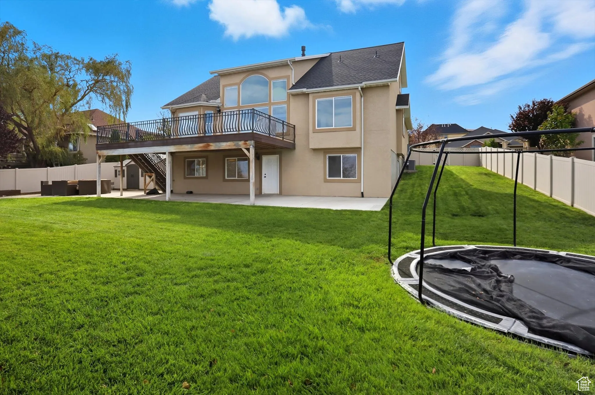 Back of property with a patio area, stucco siding, a deck, stairway, and a fenced backyard