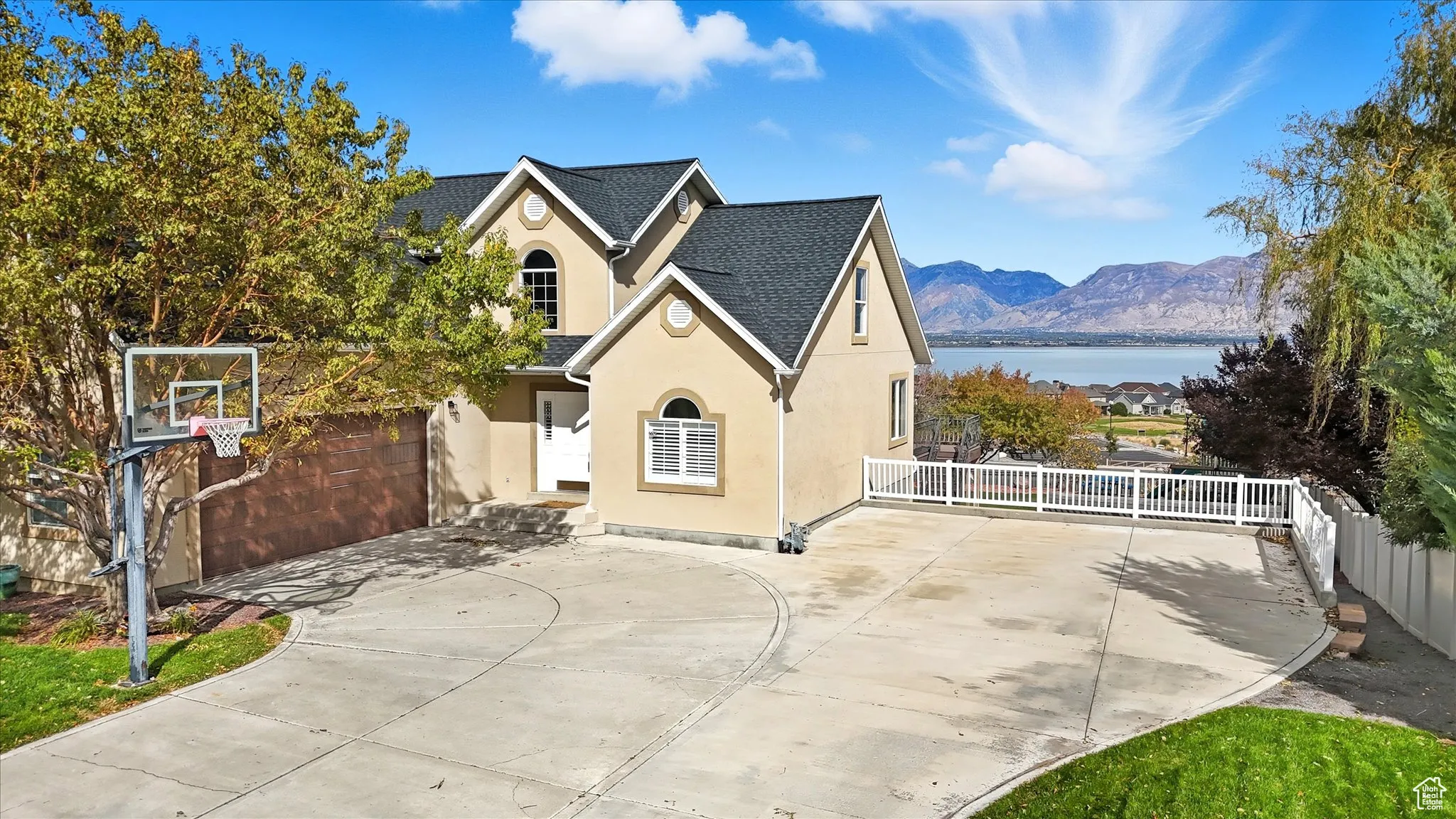 Rear view of property featuring stucco siding, a water and mountain view, and roof with shingles