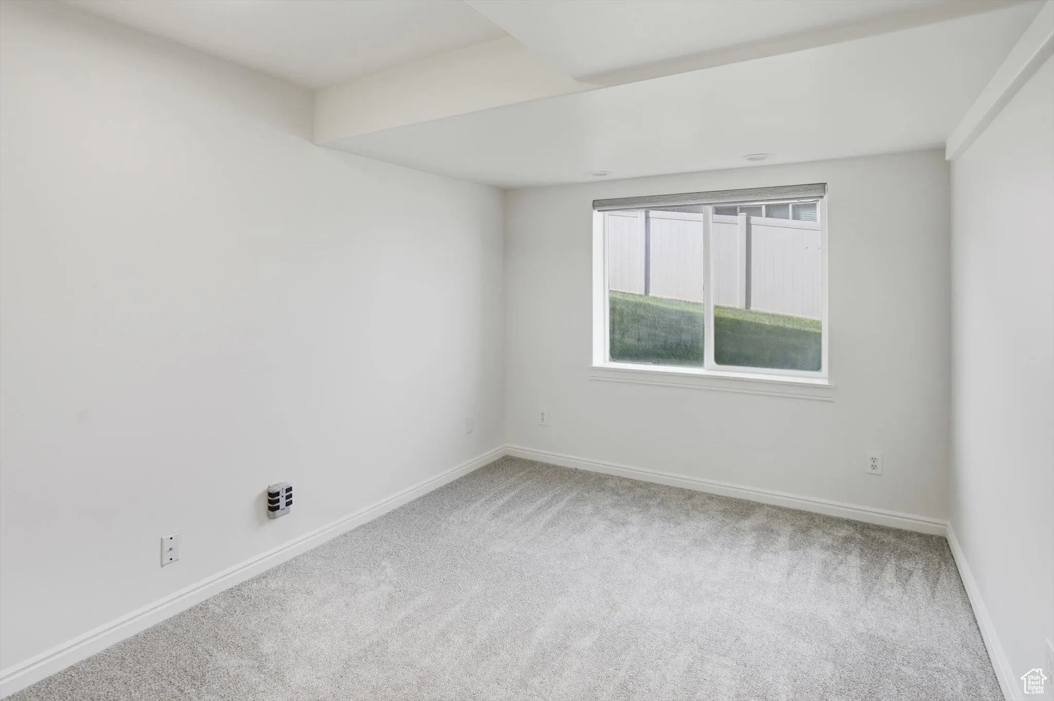 Empty room with light carpet and baseboards