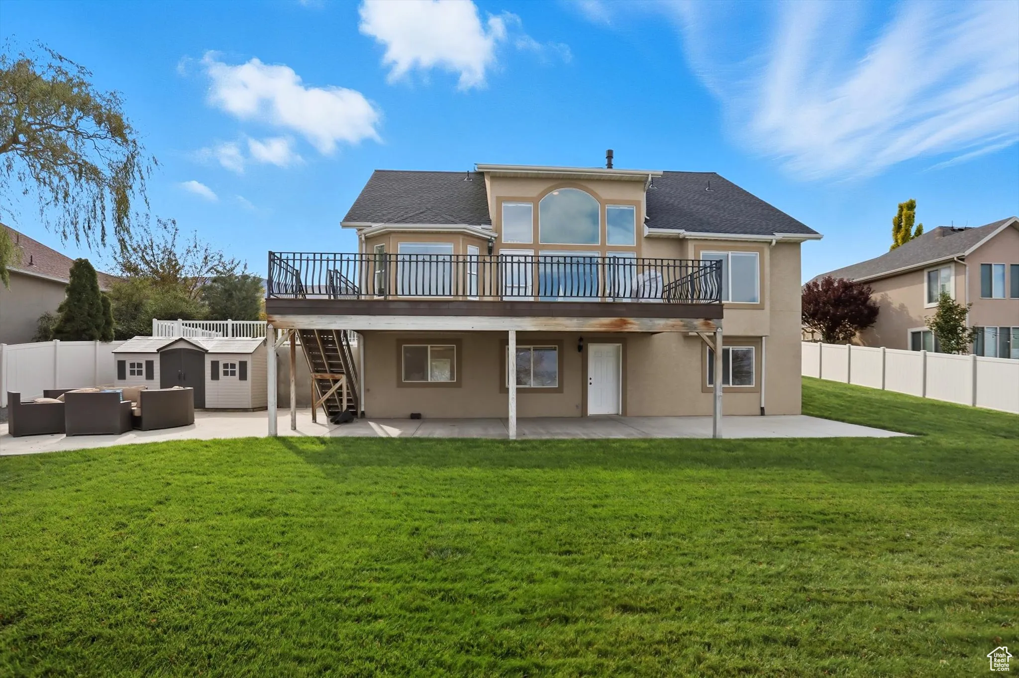 Back of property featuring a patio, stucco siding, stairway, a fenced backyard, and an outdoor hangout area
