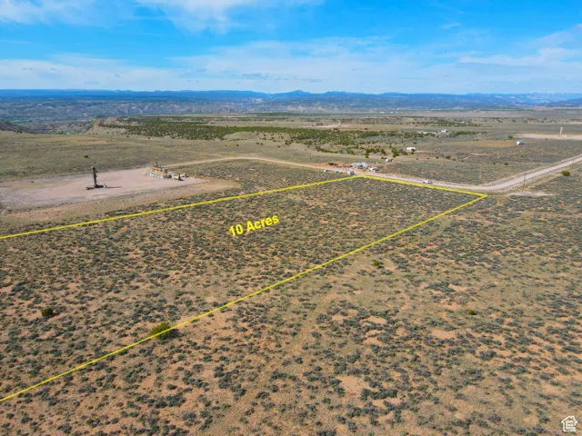 Aerial view of sparsely populated area with property parcel outlined and a mountain backdrop