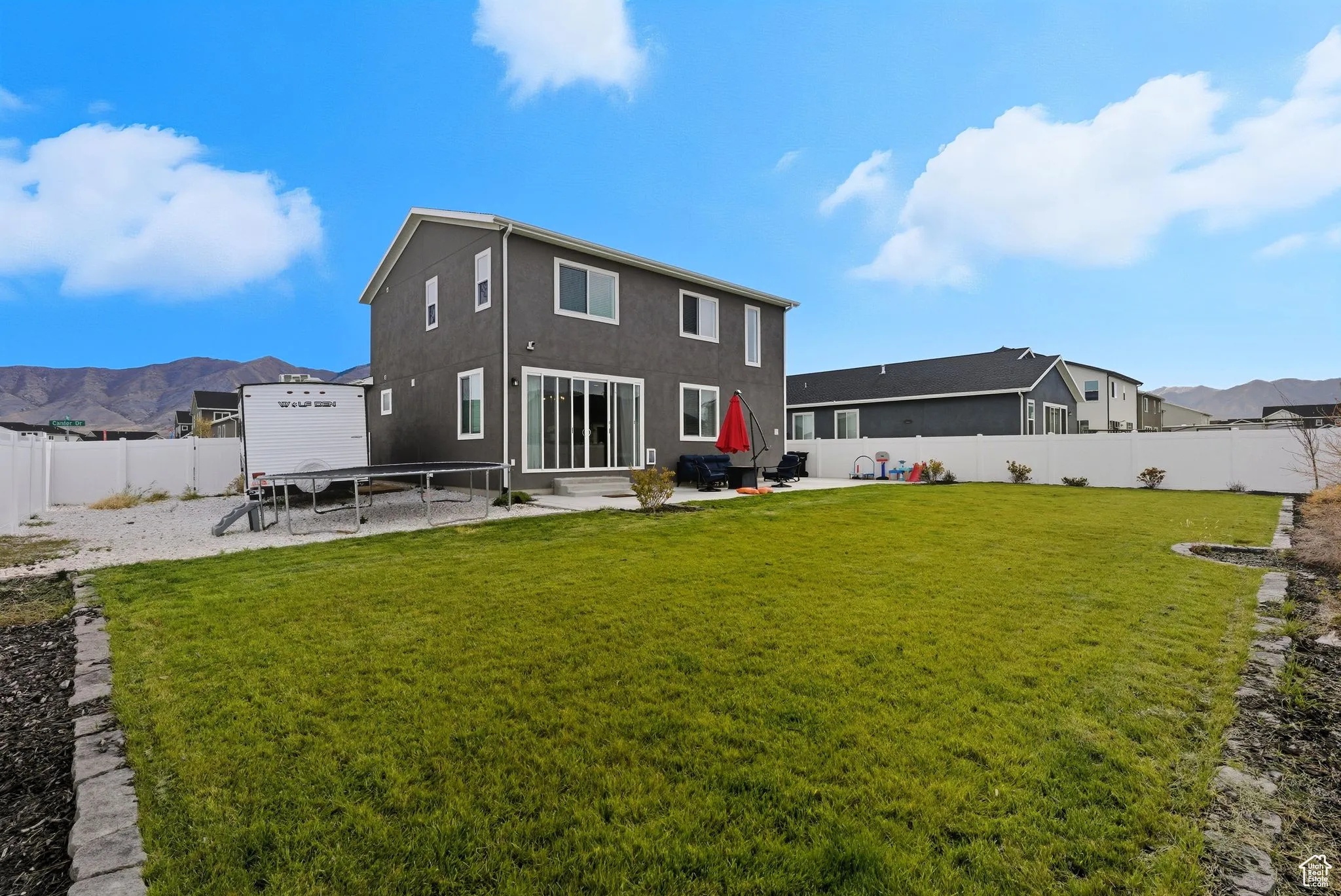 Back of house with a mountain view, a fenced backyard, a patio, and entry steps