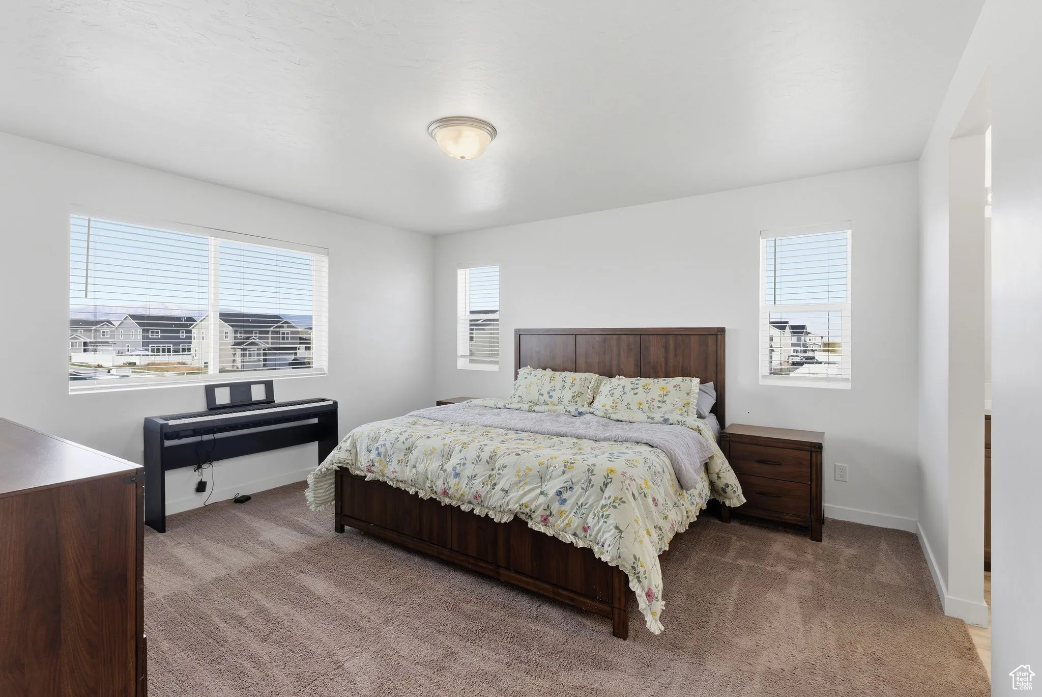 Bedroom featuring light carpet and baseboards