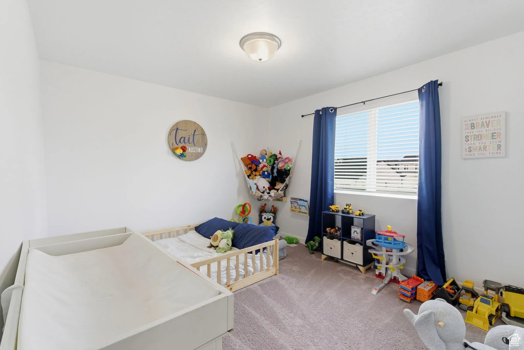 Bedroom with light carpet and a crib