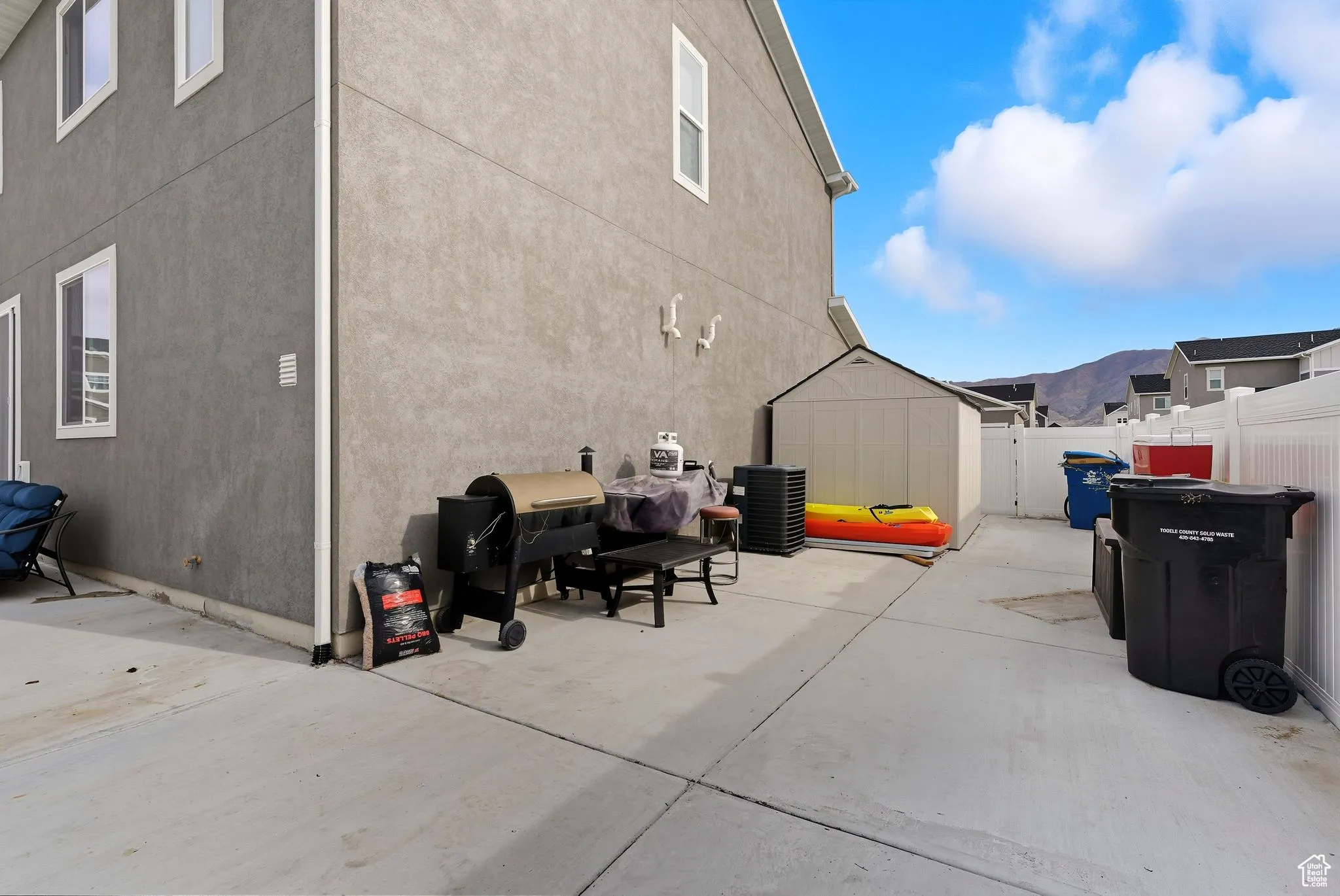 Fenced backyard with a storage unit, area for grilling, and a mountain view