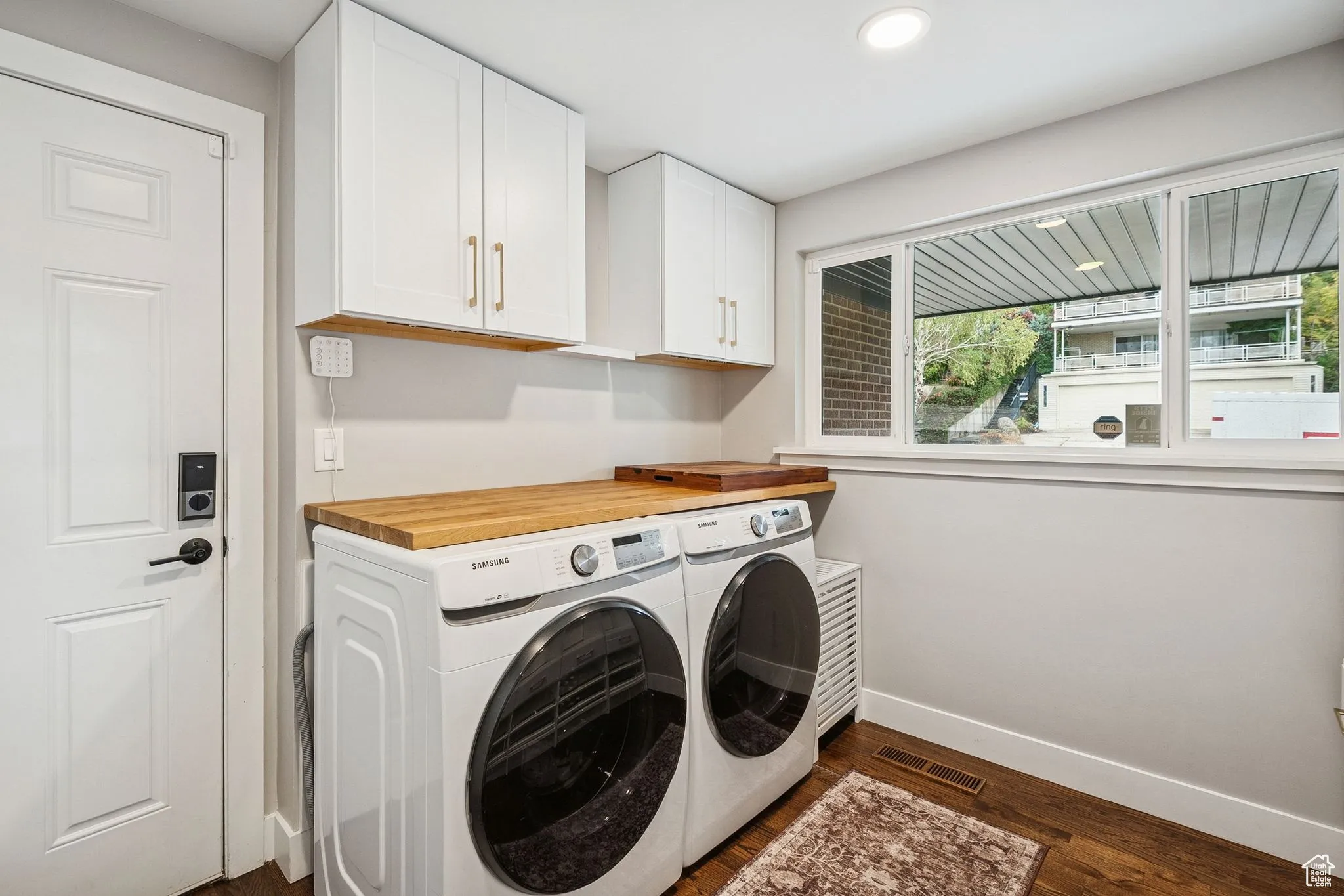 Washroom featuring dark wood finished floors, cabinet space, separate washer and dryer, and recessed lighting