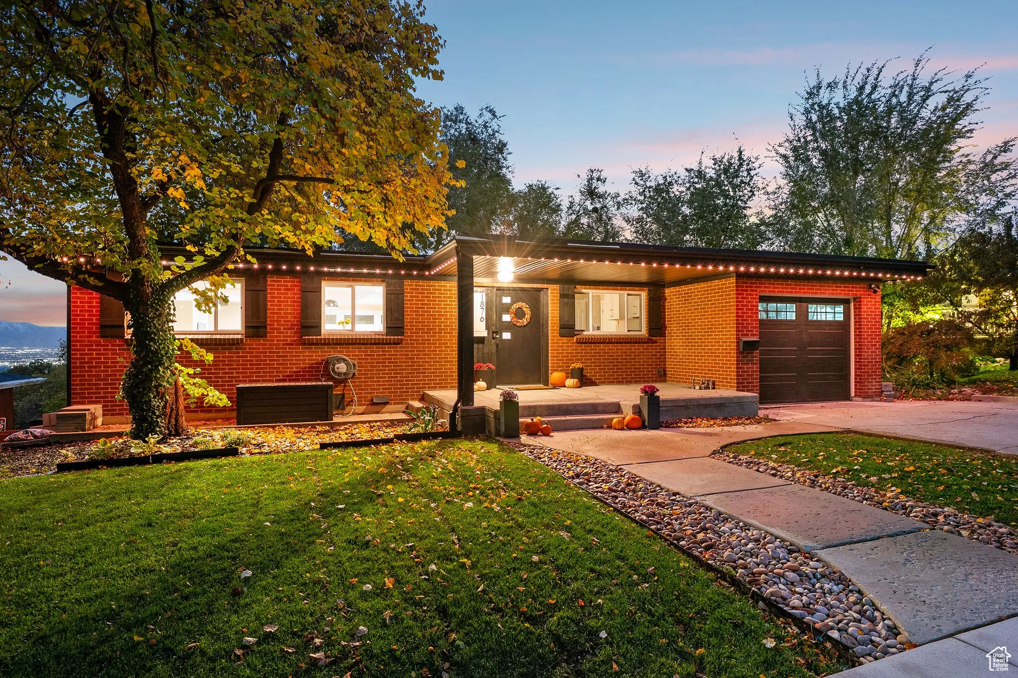 Single story home featuring brick siding, an attached garage, and a lawn