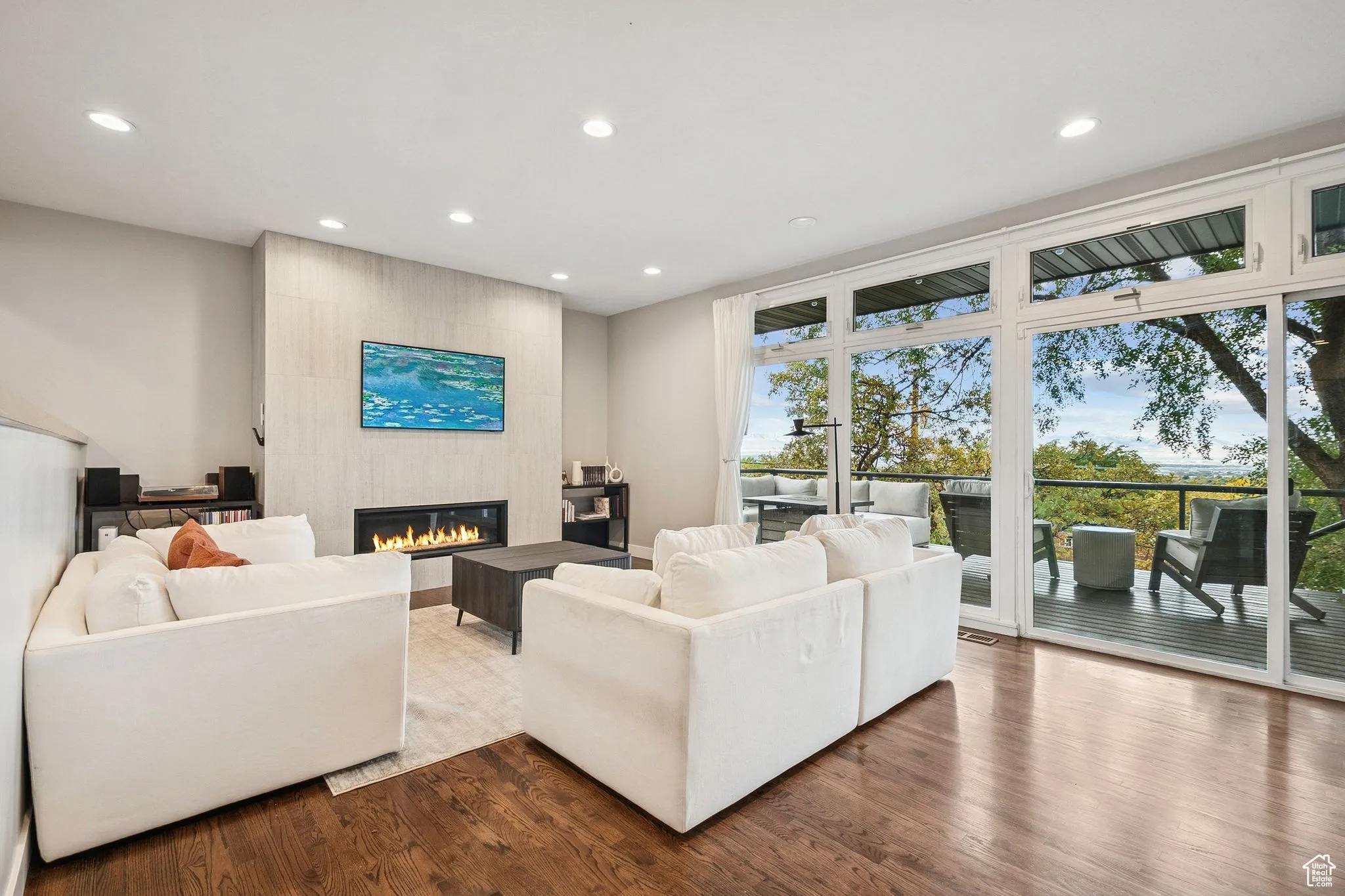 Living area with recessed lighting, a fireplace, and wood finished floors