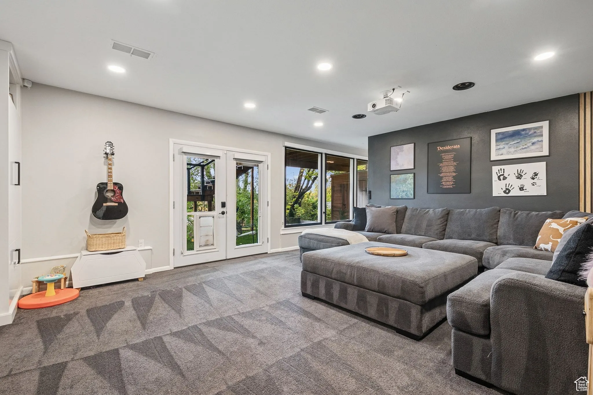 Carpeted living room with recessed lighting and french doors