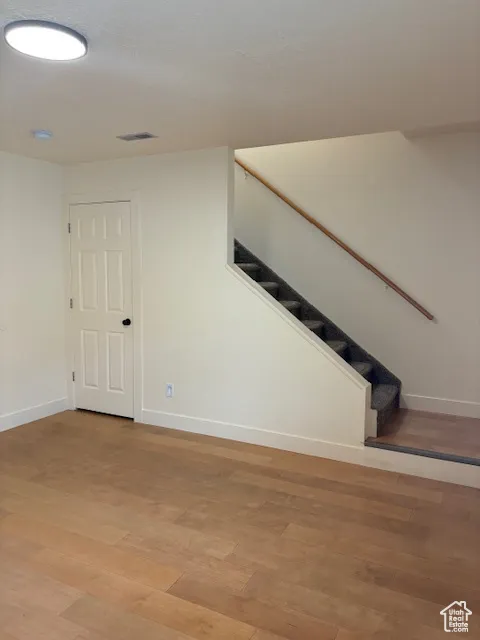 Staircase with wood finished floors and baseboards