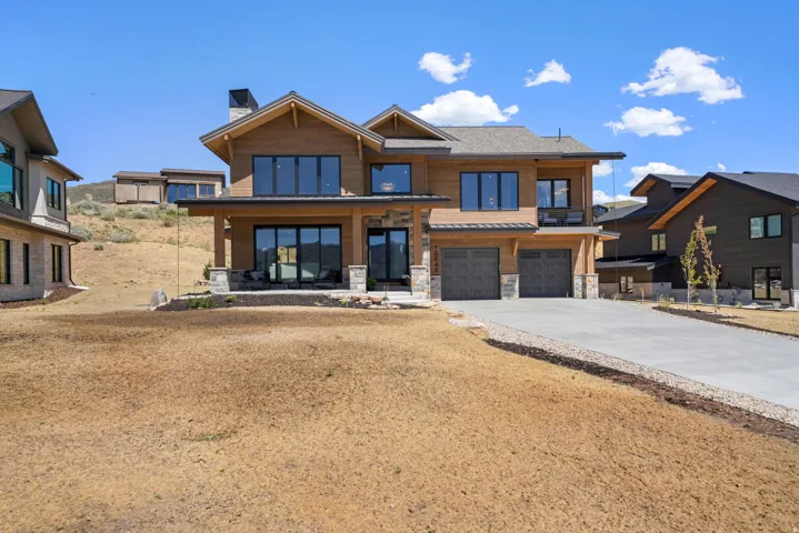 Contemporary wood-sided residence featuring a stone-clad foundation and chimney