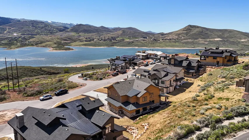 Aerial perspective showcasing a residential community with lake scenery and distant mountains