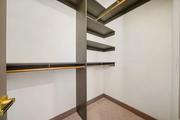 Custom closet system featuring wood-finish shelving and hanging rods