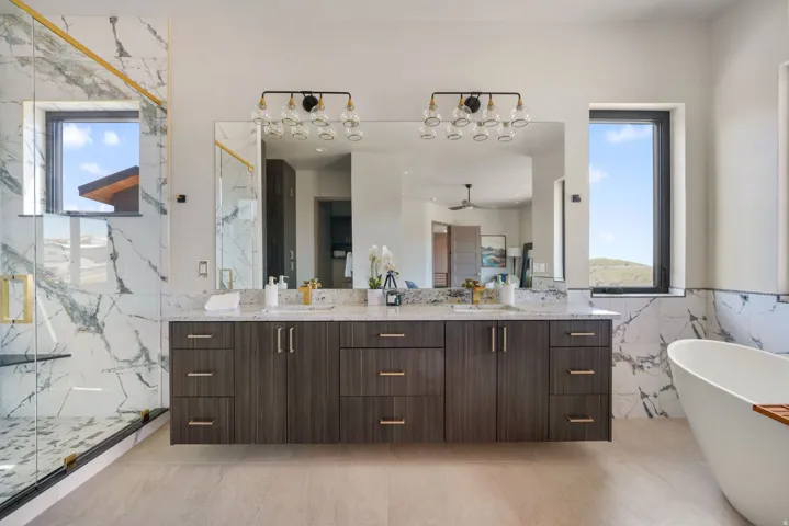 Spacious bathroom featuring a dual vanity with dark wood-finish cabinetry and light-toned countertops