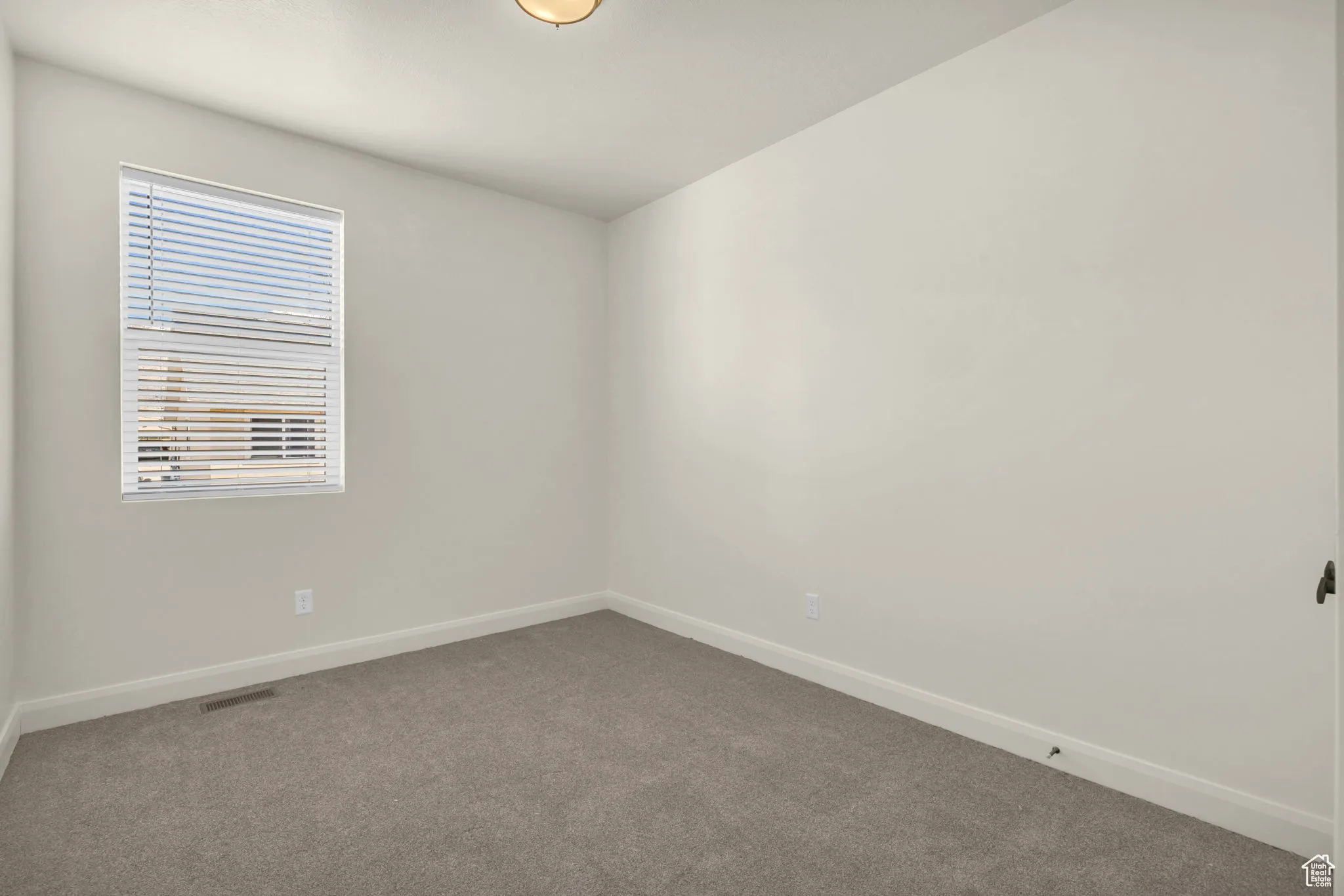 Carpeted empty room with baseboards
