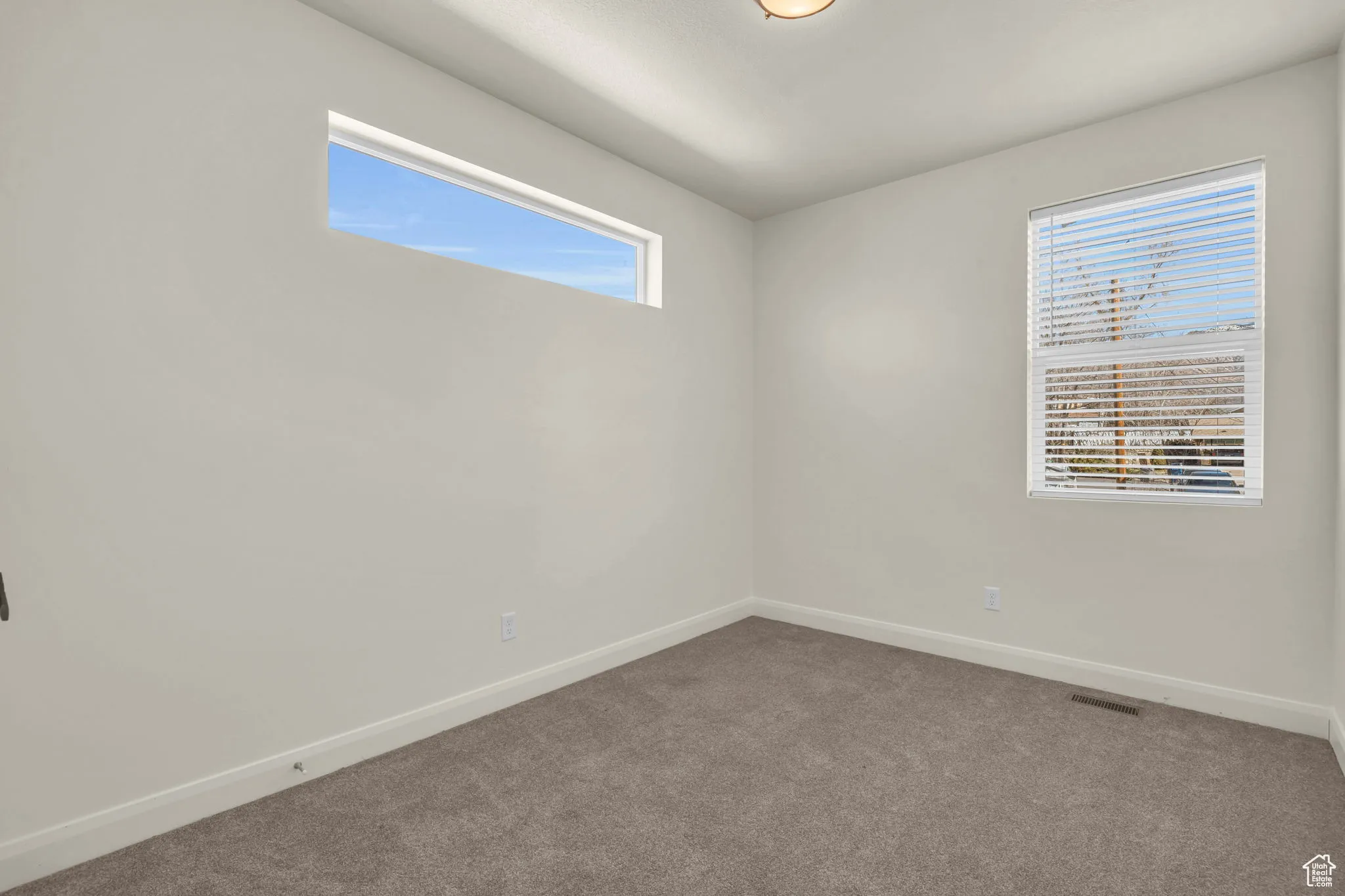 Empty room featuring baseboards and carpet flooring