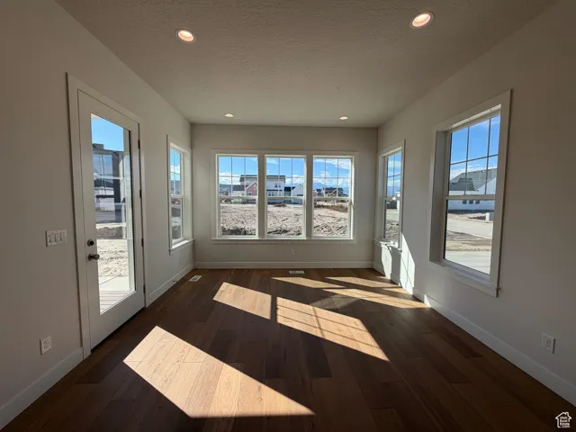 Unfurnished sunroom featuring recessed lighting, wood finished floors, and a textured ceiling