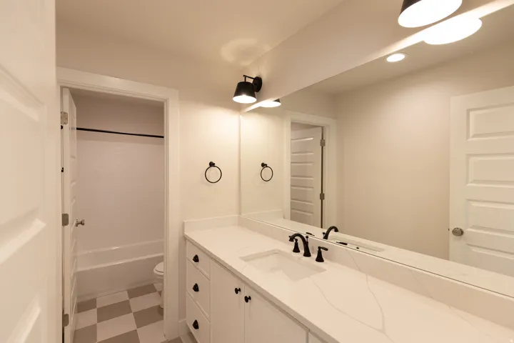 Full bathroom featuring vanity, dark flooring, tub / shower combination, and recessed lighting