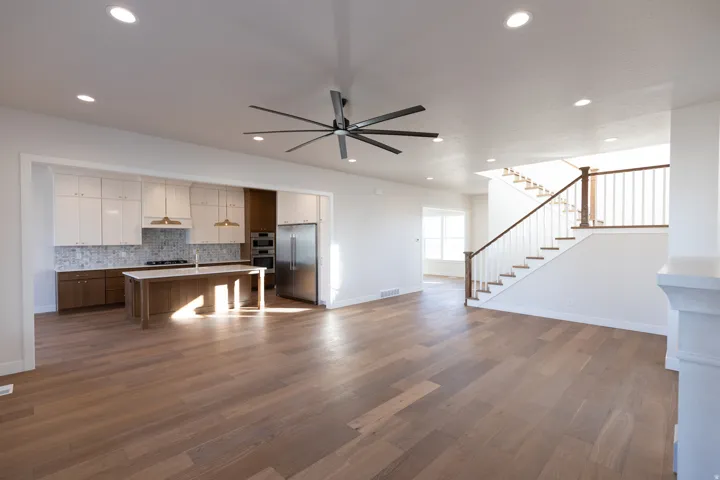 Kitchen with open floor plan, light countertops, two tone cabinets, a center island, and stainless steel appliances