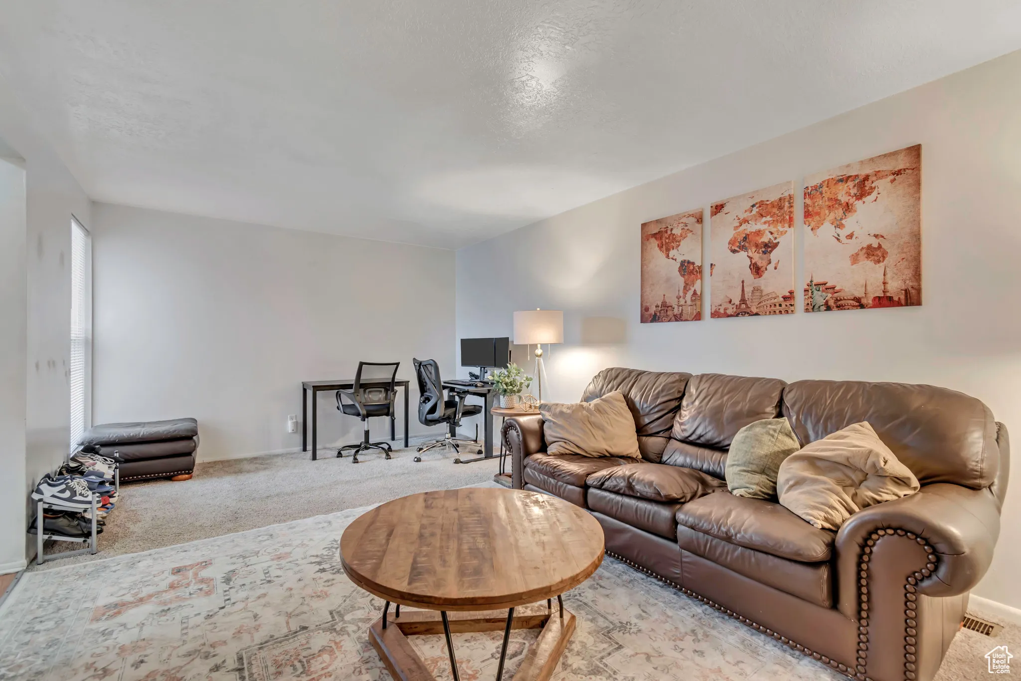 Carpeted living area featuring a desk and a textured ceiling