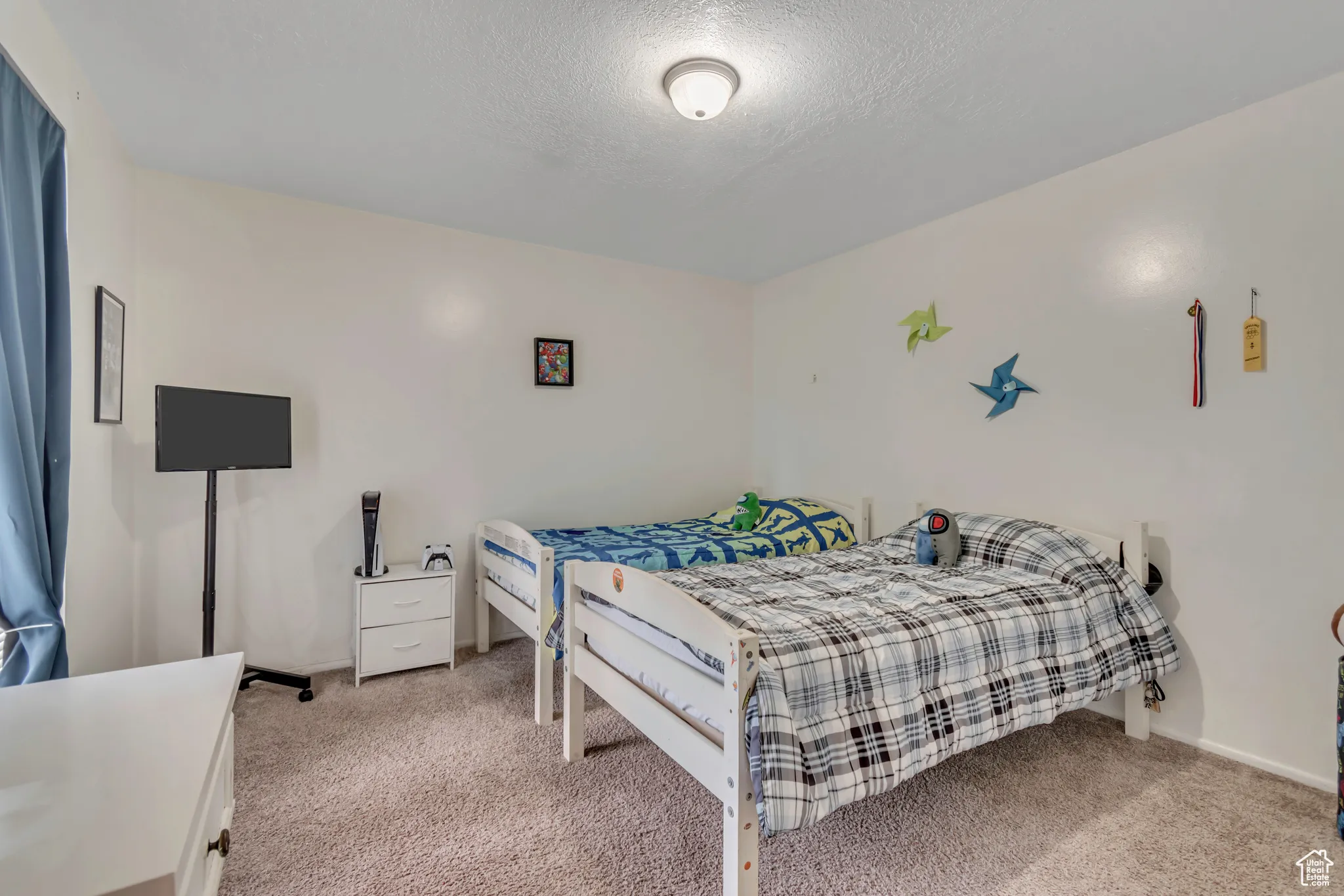 Bedroom with light colored carpet and a textured ceiling
