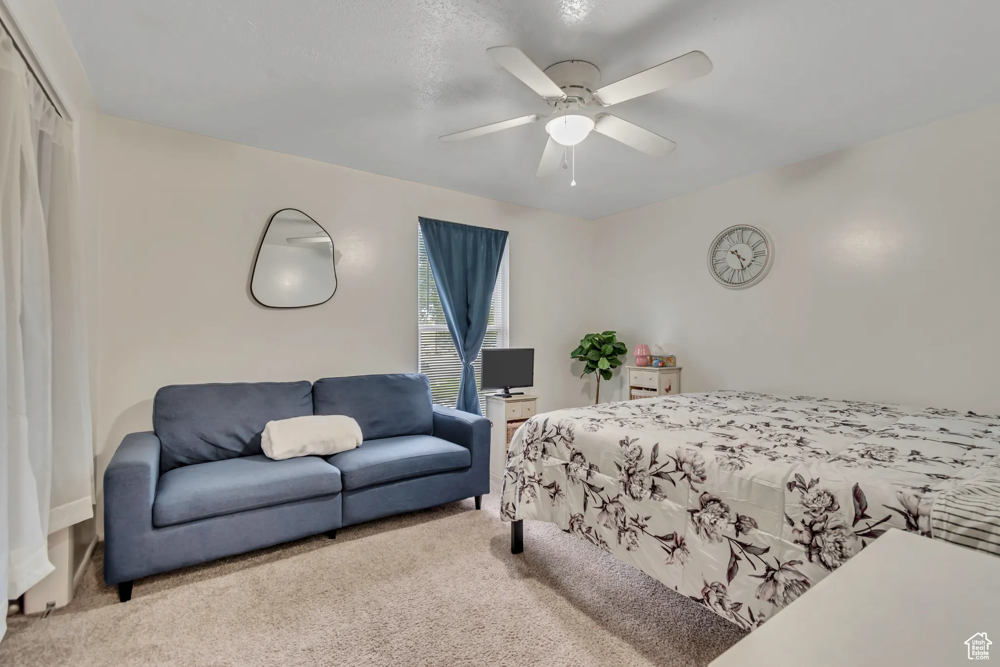 Carpeted bedroom featuring a ceiling fan