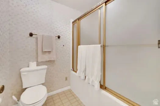 Full bathroom with enclosed tub / shower combo.